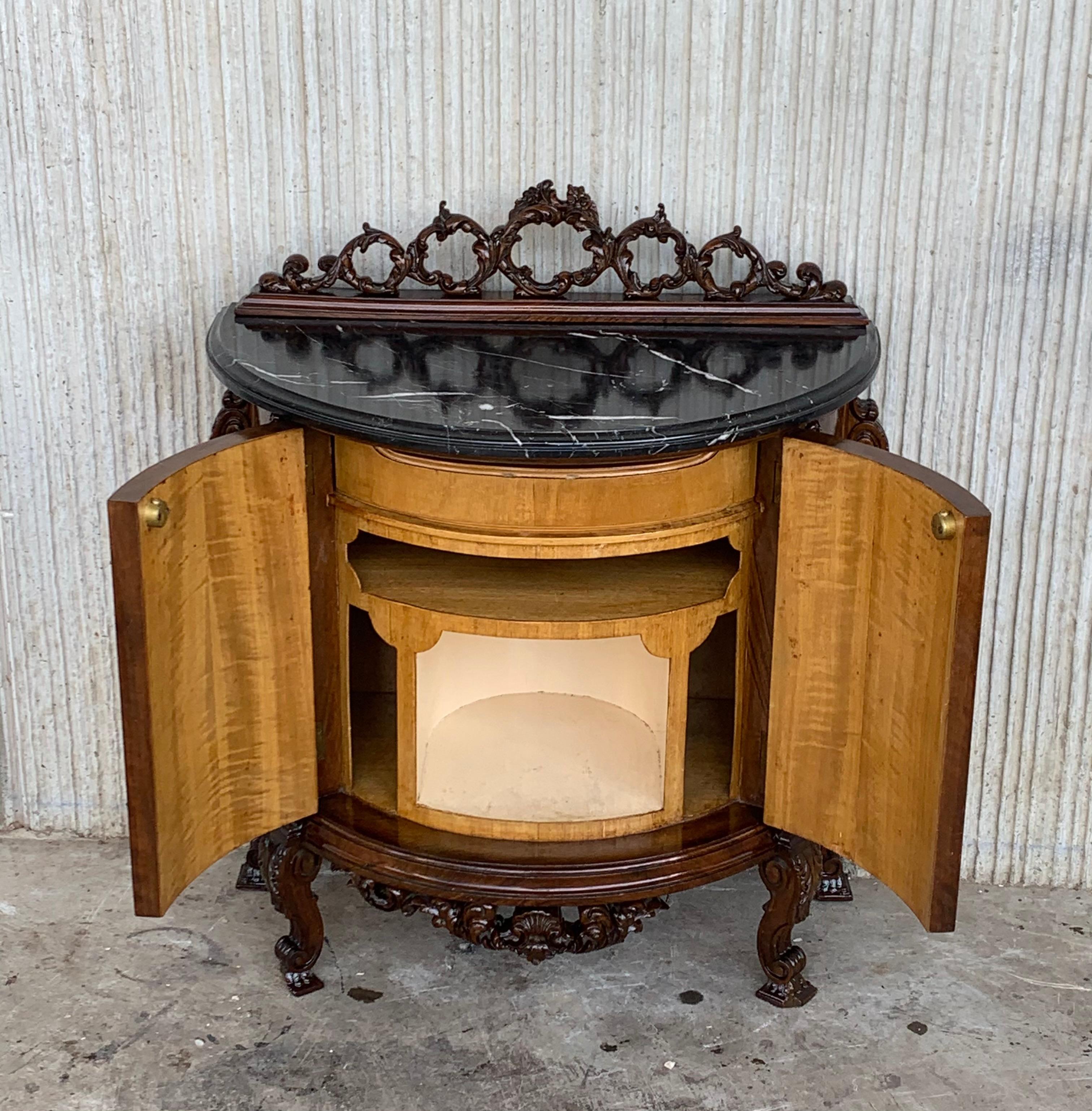 20th century French pair of carved and marquetry nightstands with two doors and hidden drawer

Beautiful pair of carved nightstands. The top has a carved crest and black marble. 
The low part has a drawer and different compartments.
The door has