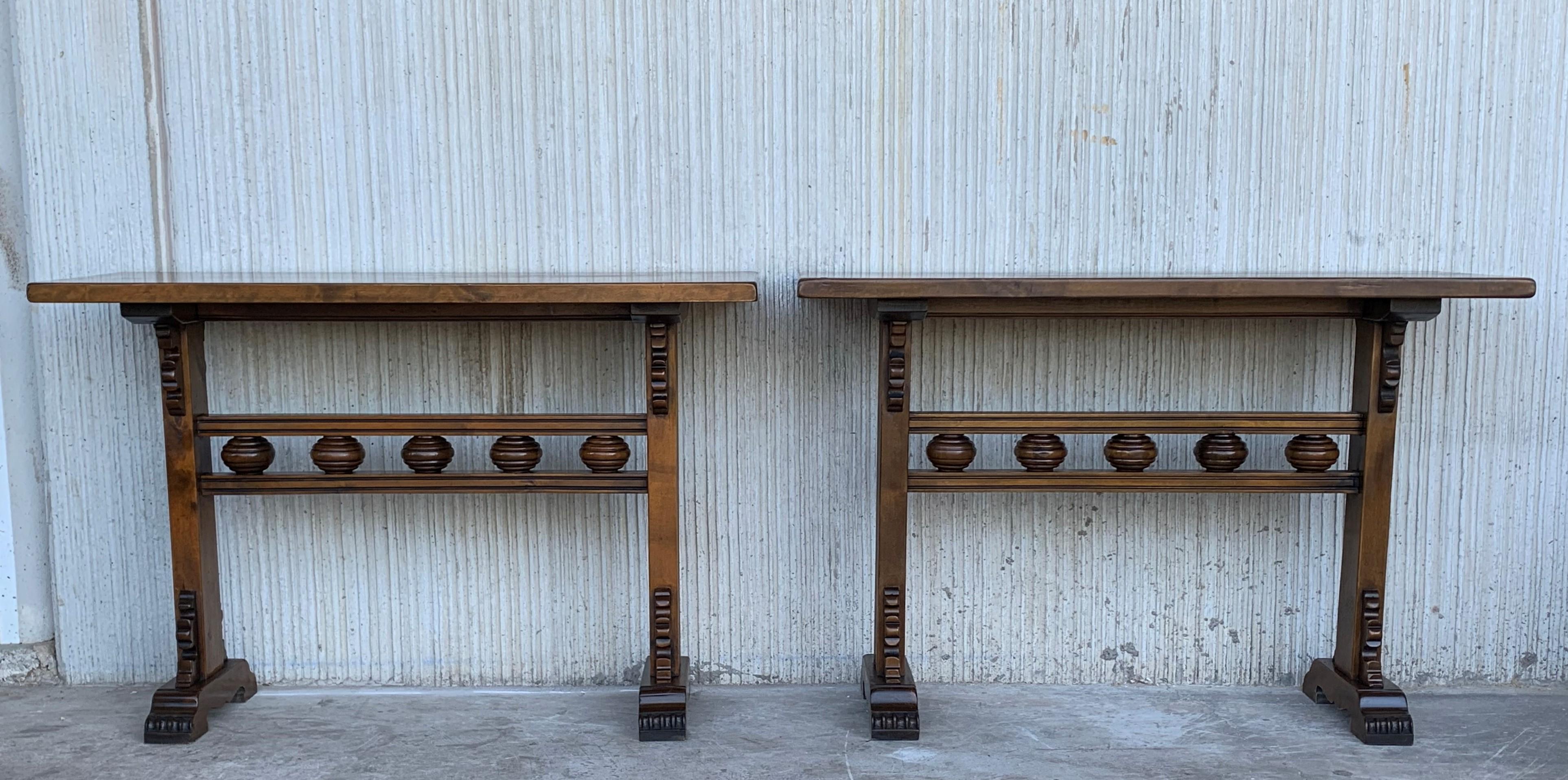 Pair of carved solid walnut console tables with beautiful patina.
It have two pedestal legs with an stretcher with carved bowls.
Very consistent and functional.
