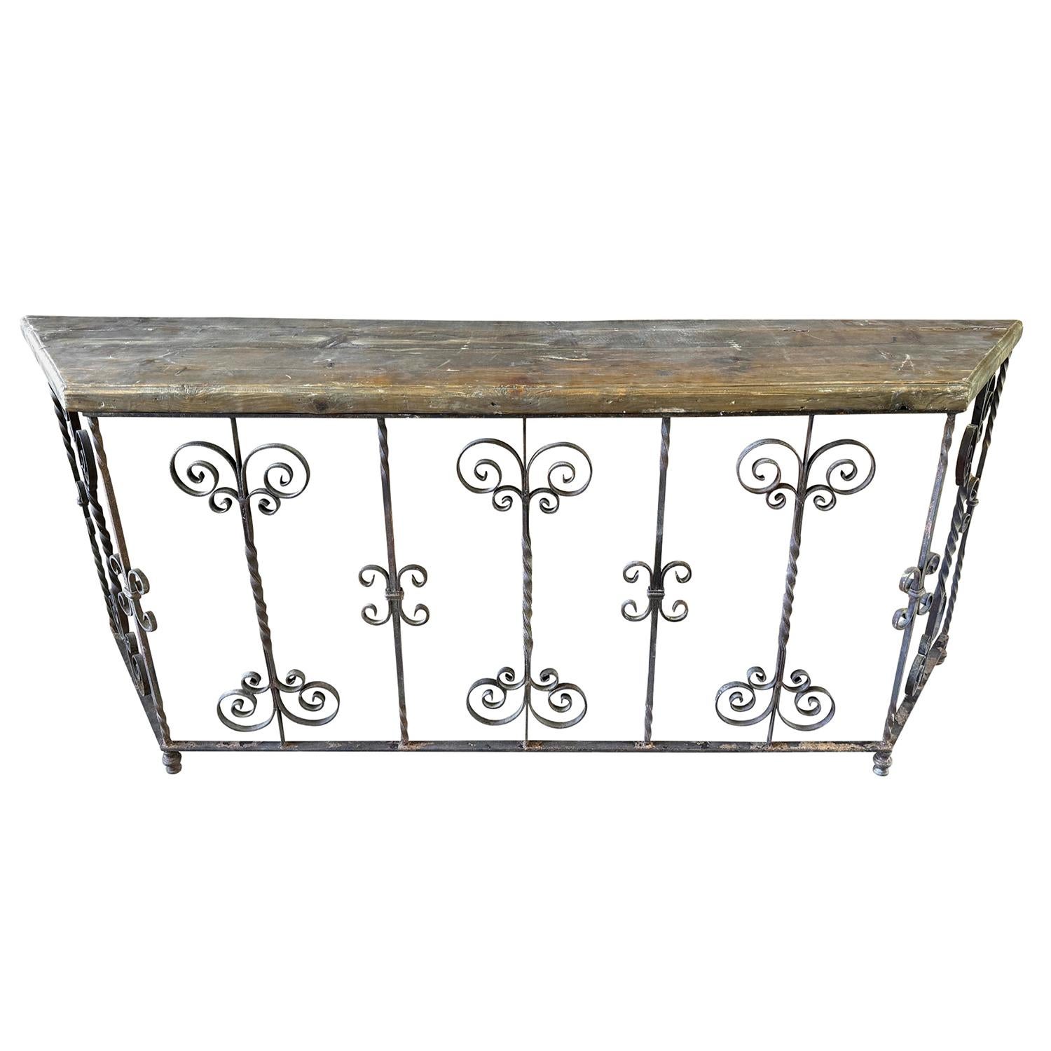 This striking pair of vintage console tables embodies the artistry of traditional European craftsmanship. Each table features a decorative wrought iron base, hand-forged with intricate scrollwork and graceful curves, showcasing both strength and