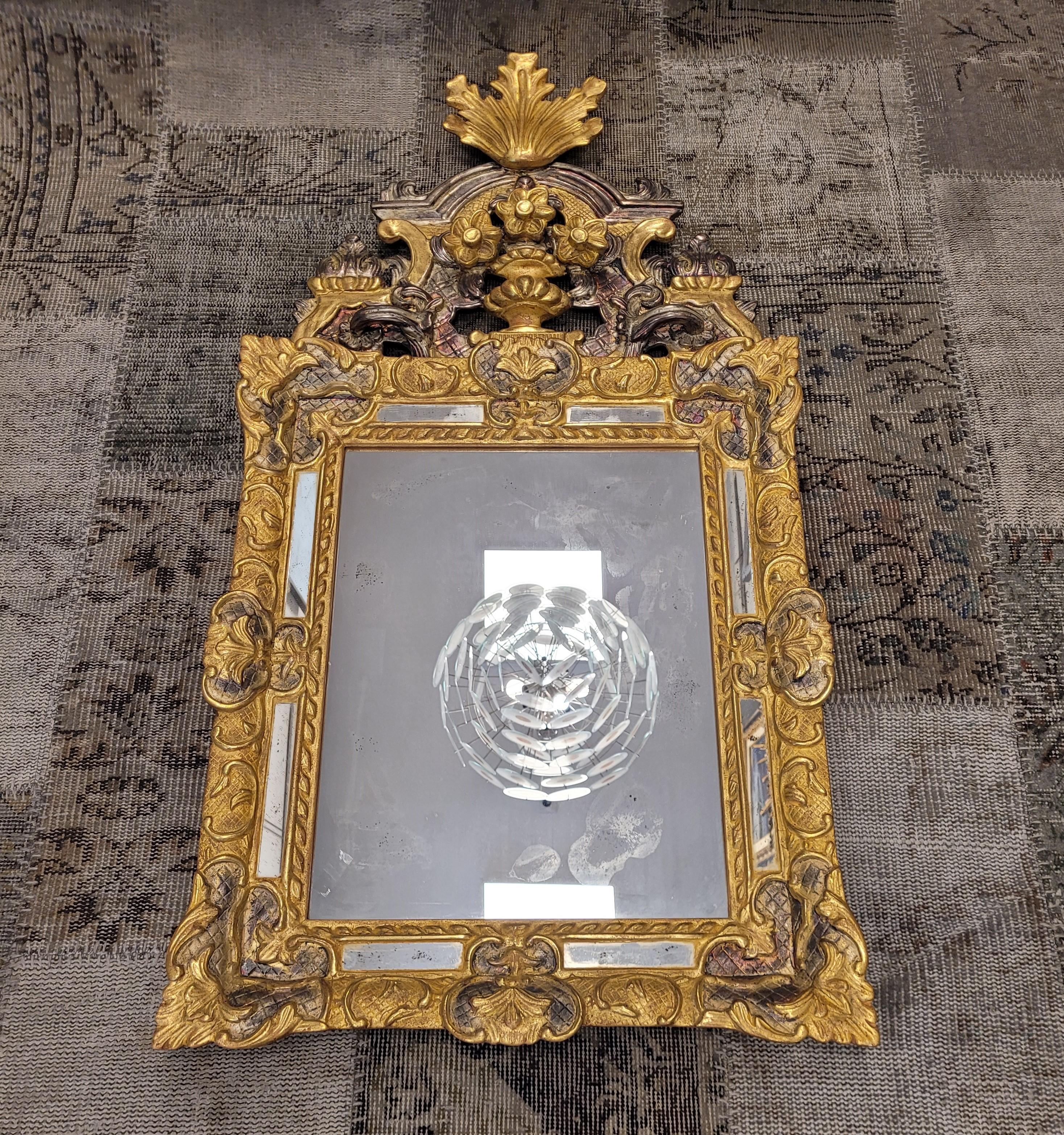 Outstanding and really gorgous mirror made by a  French master craftsman, following the extraordinary mirrors Louis XIV (1643 – 1715). Made of finely carved , gilded and silver  wood with an aged effect. Body with a quadrangular profile and an