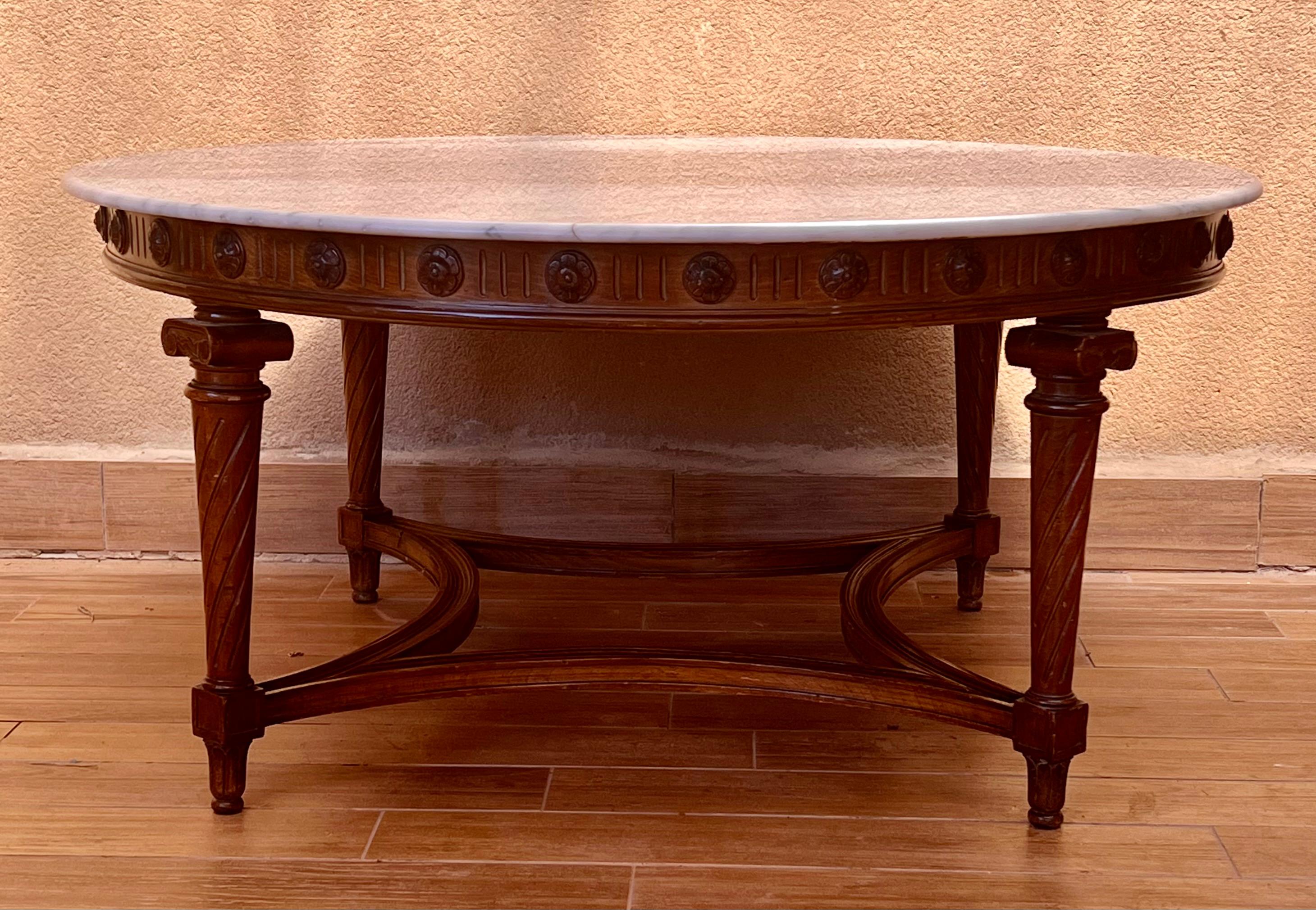 20th round coffee table with marble top, carved legs & wood stretcher.