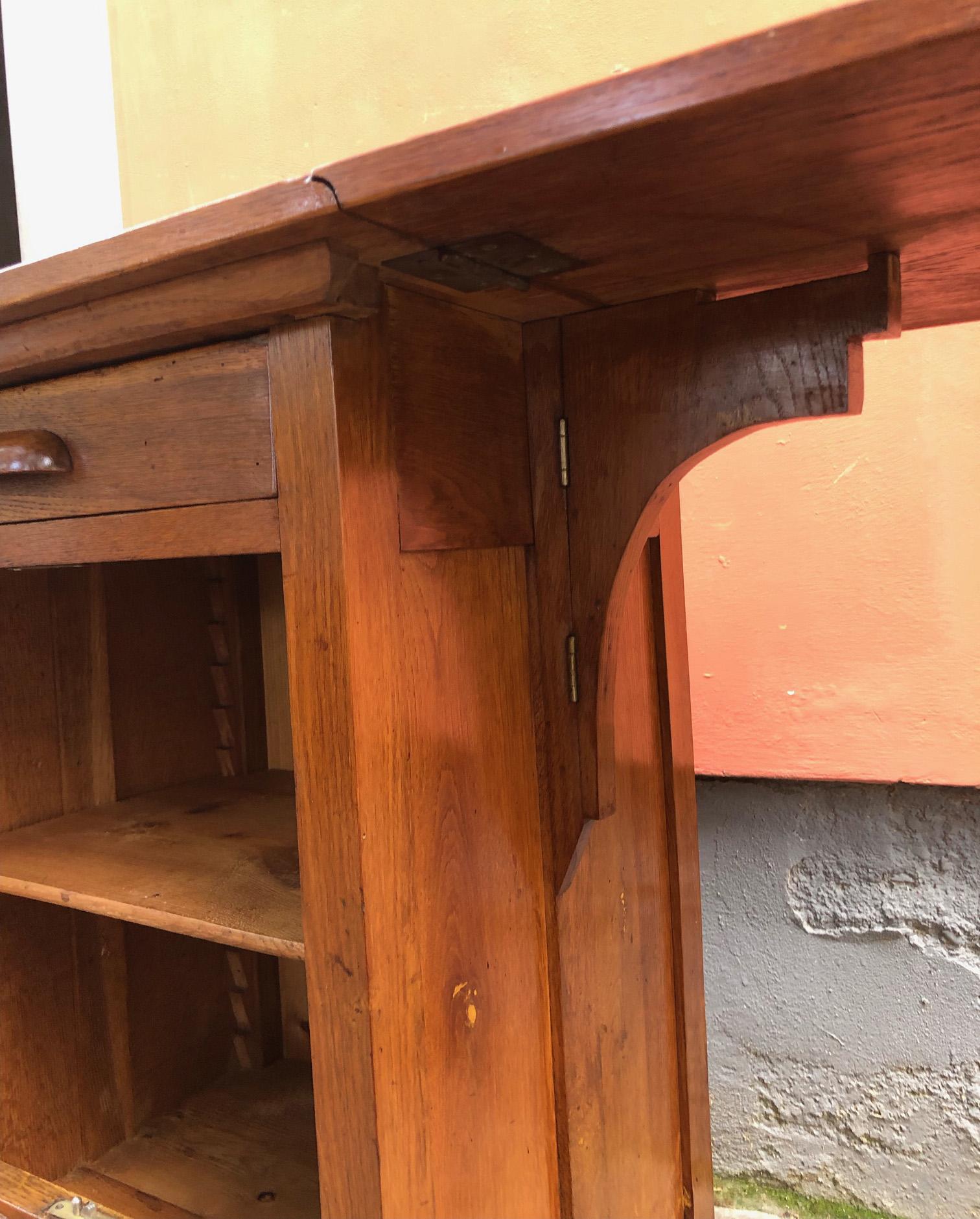 20th century sideboard table in solid oak with rolling shutter and internal top.
The right side part can be raised at will and a comfortable table is created.
Rare shape and size. The table when open measures 46 x 95 cm.
Very practical and