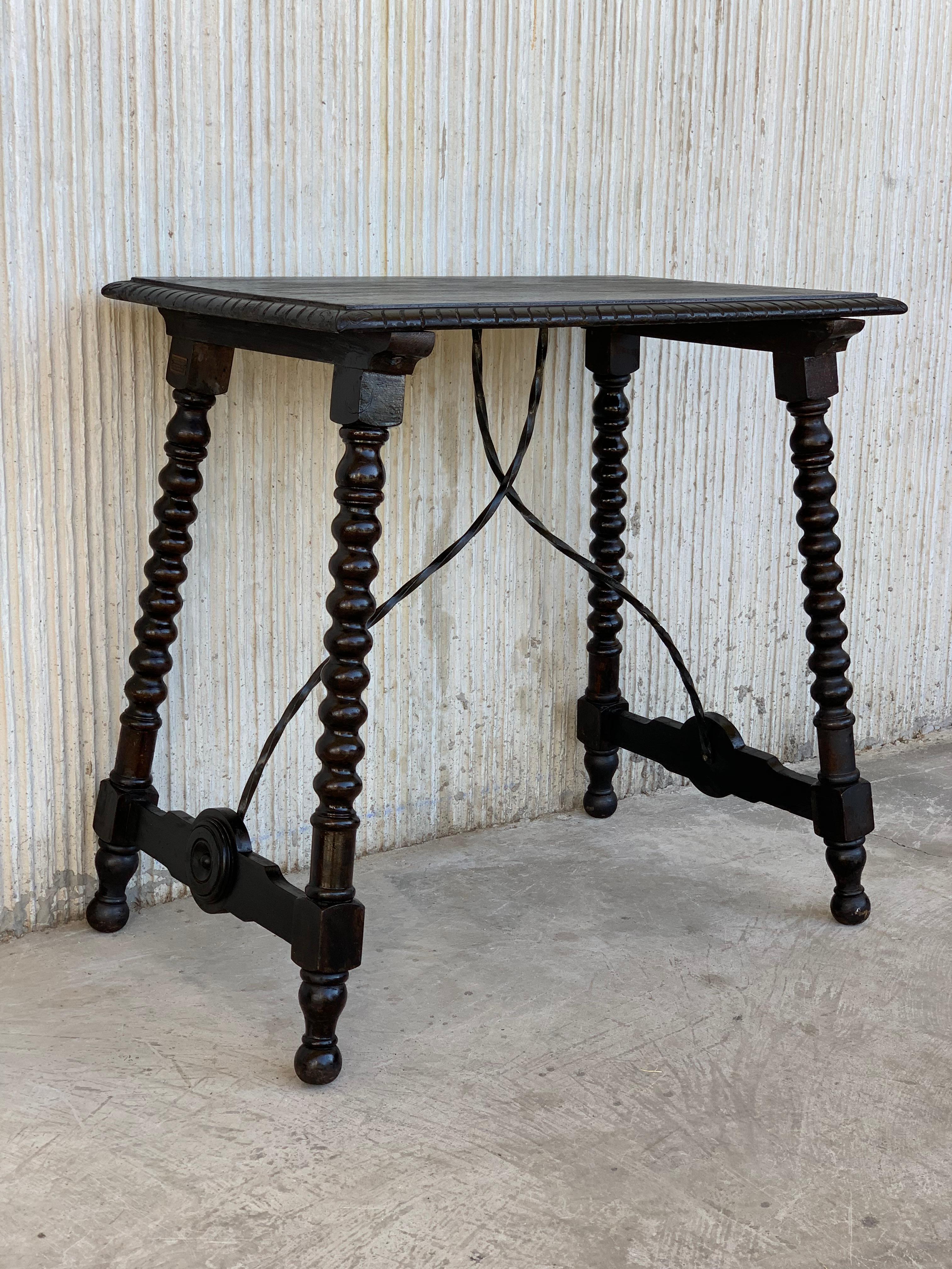 20th century Spanish Baroque ebonized side table with iron stretcher and carved top in walnut.
