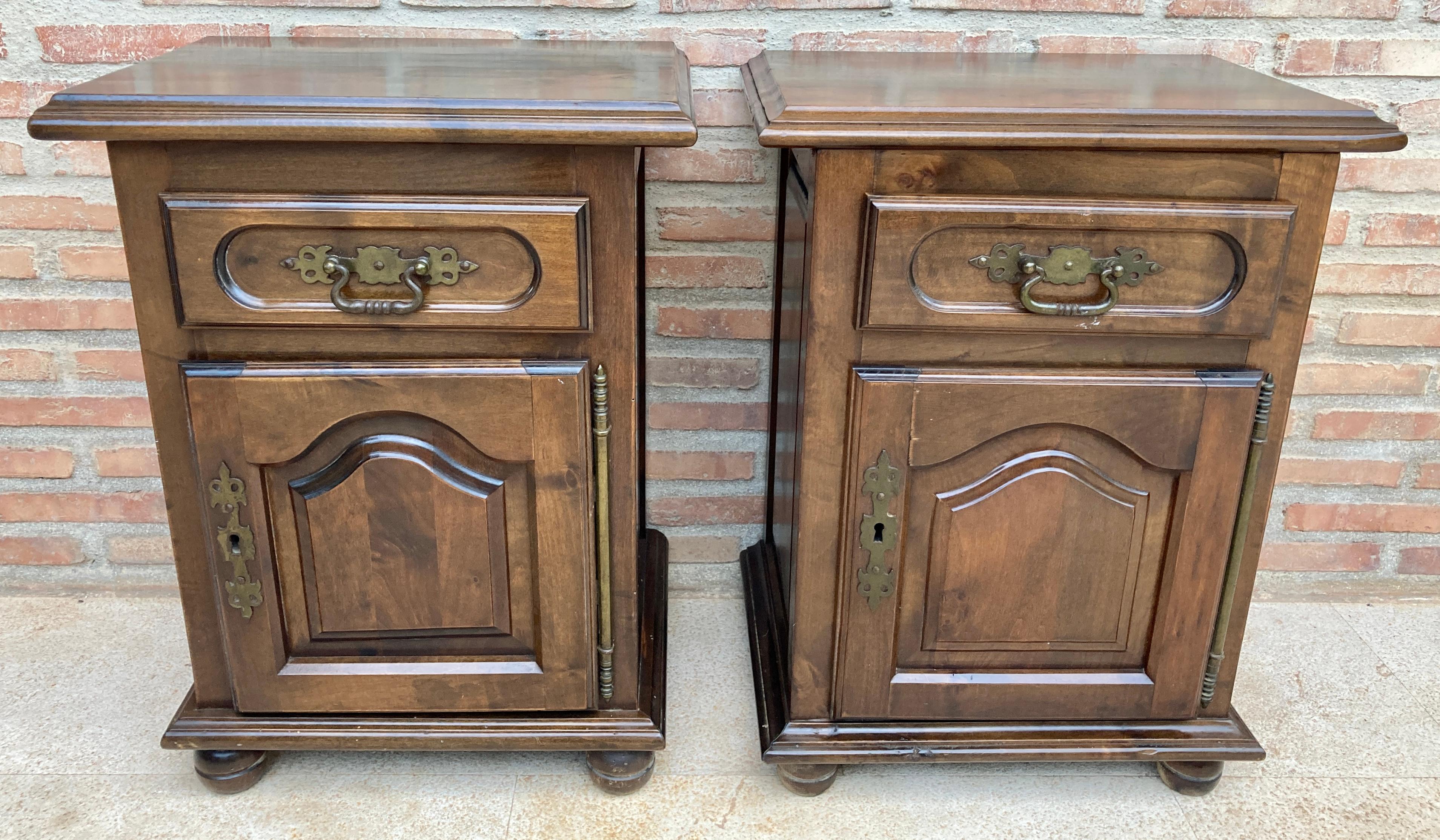 20th century pair of Spanish nightstands with one carved drawer, one door and bronze hardware. 
Beautiful tables that you can use like a night stands or side tables, end tables... or table lamp. 
Design Period 1920 to 1949 
Year 1920 
Production