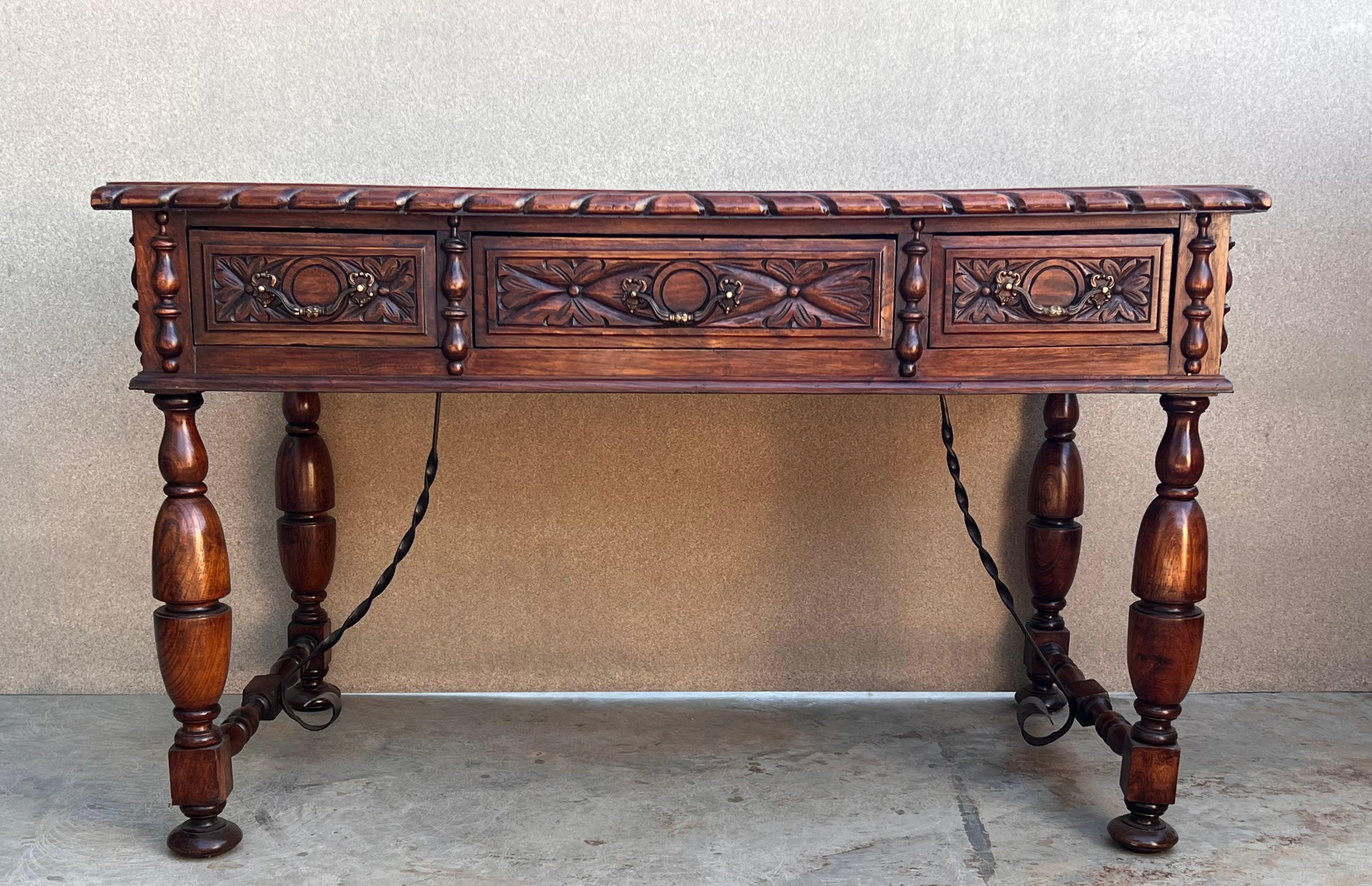 This elegant fruitwood desk was created in France, circa 1920. Made of blond walnut timber, the large writing table sits on four carved legs with two iron stretchers. The front has a wide opening with plenty of knee space and the back is embellished