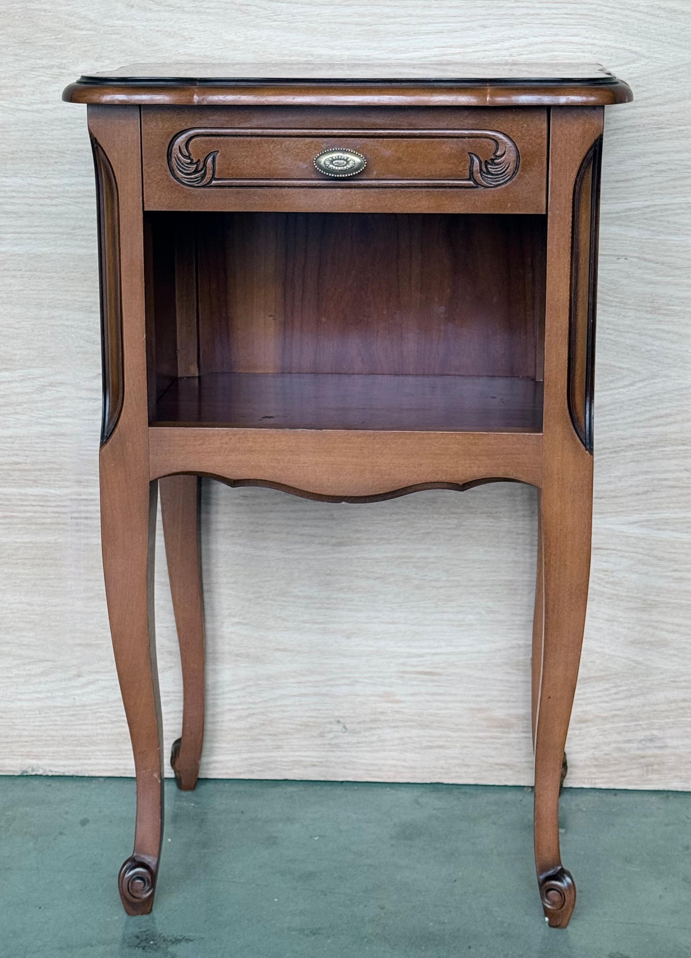 A pretty pair of French walnut nightstands and one drawer with open shelf, circa 1940. 
Pair of French Louis XV style walnut bedside tables from the early 20th century. This pair of French 'tables de chevet' were created in the early 20th century,