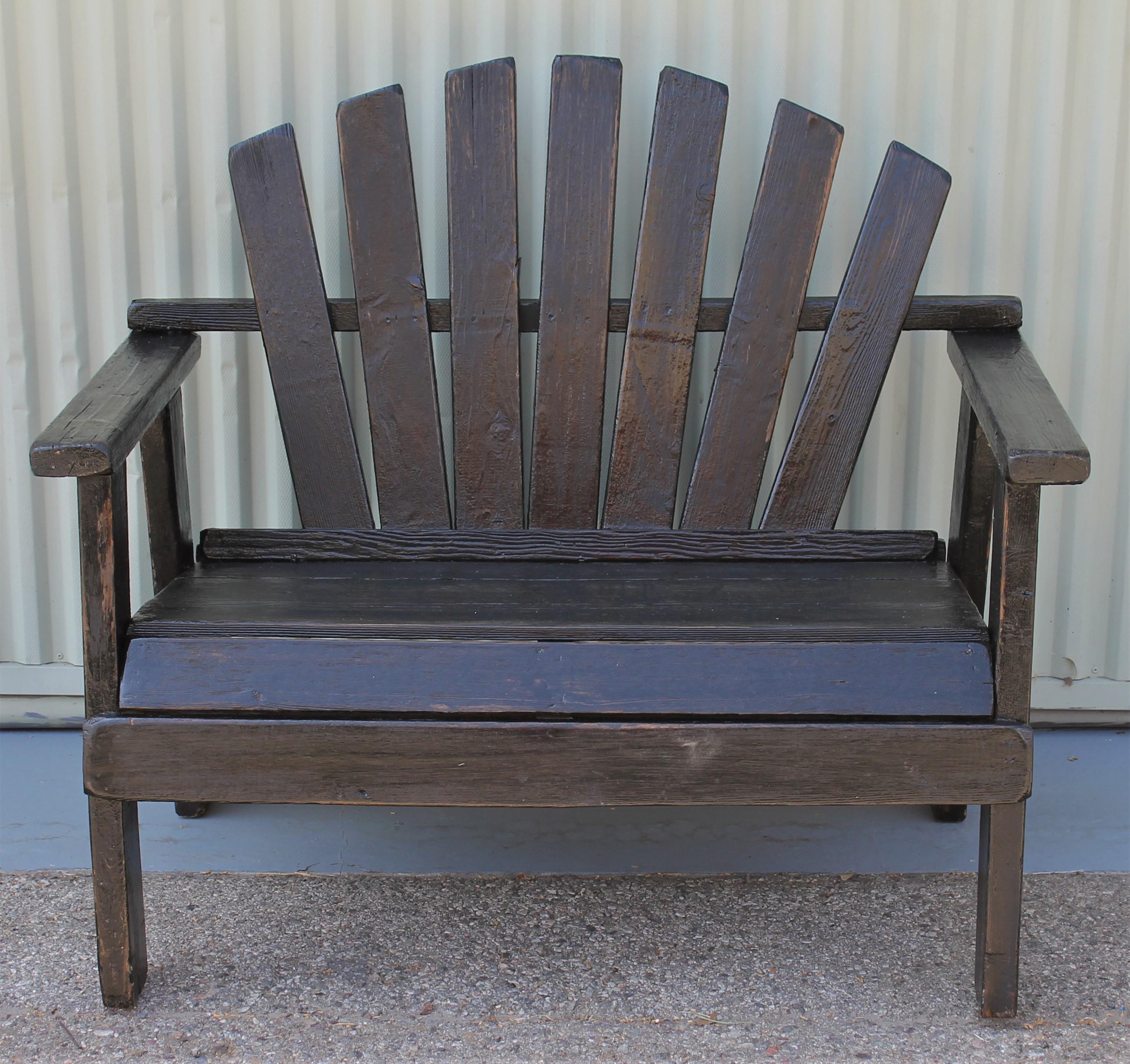 This fine bench is in old black worn paint with a coating of outdoor weather protector. It can be flat or satin surface but protects from rain or beach salt water air born. This settee comes from a mid-western cabin feel. The side chair matches the