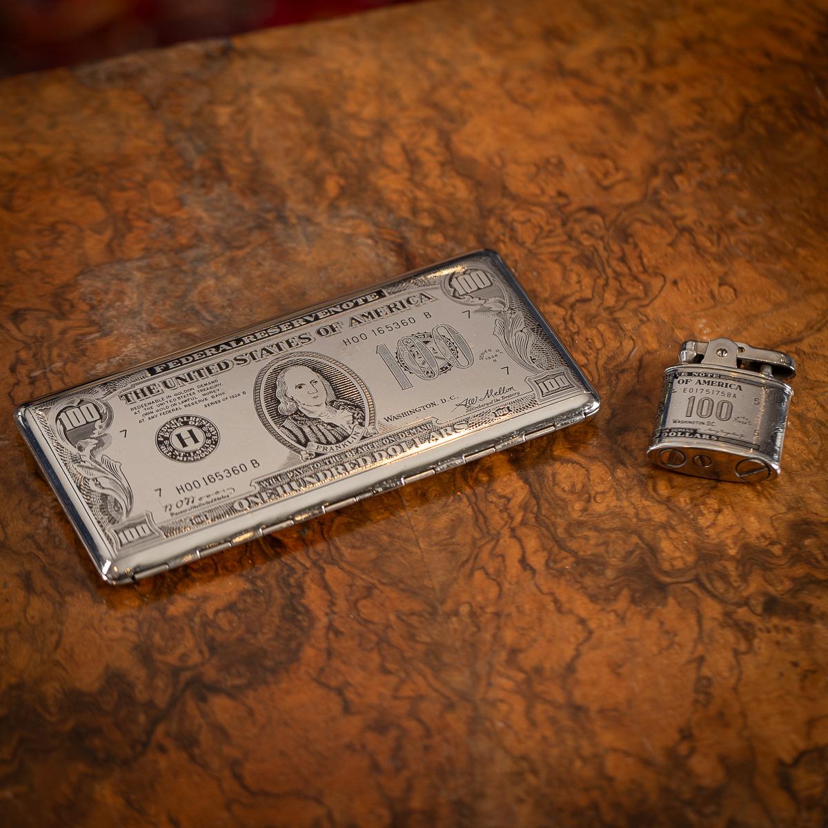 Un superbo portasigarette e accendino americano placcato in argento del XX secolo.

Progettato per assomigliare a una banconota da 100 dollari, il cofanetto raffigura Benjamin Franklin (1706-1790), polimatico-scienziato, inventore, diplomatico,