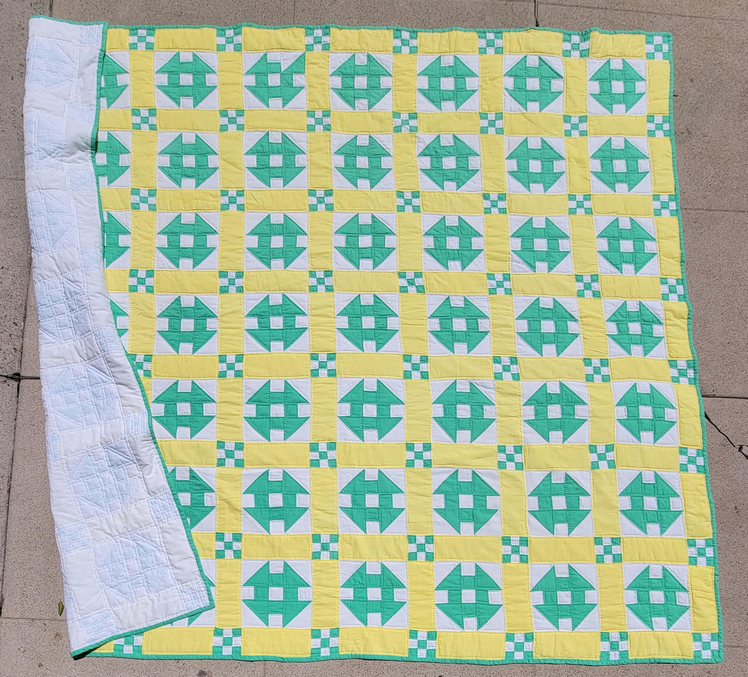 This fun hole in the barn door pattern quilt is in butter cup yellow and mint green colors.The condition is very good and mint.These fun spring colors are really wonderful.Notice the nine patch corners that flank along the monkey wrench or hole in