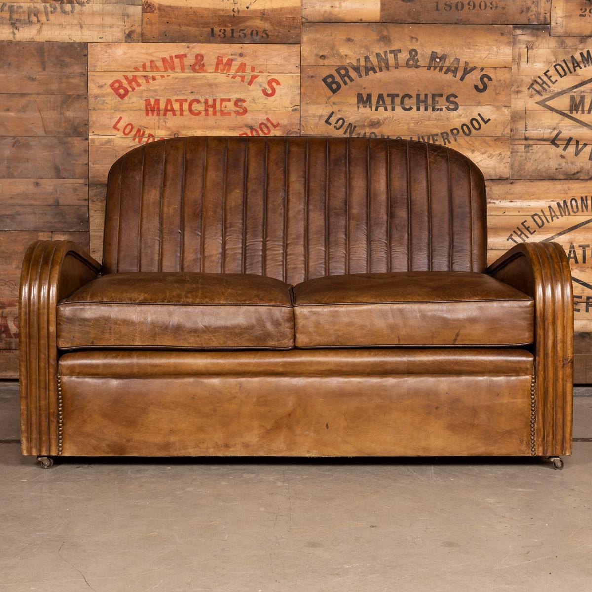 Antique early 20th century Art Deco suite, consisting of a pair of matching tub chairs and a sofa. Showing superb patina and color, this wonderful pair of club chairs were hand upholstered sheepskin leather by the finest craftsmen and mounted with