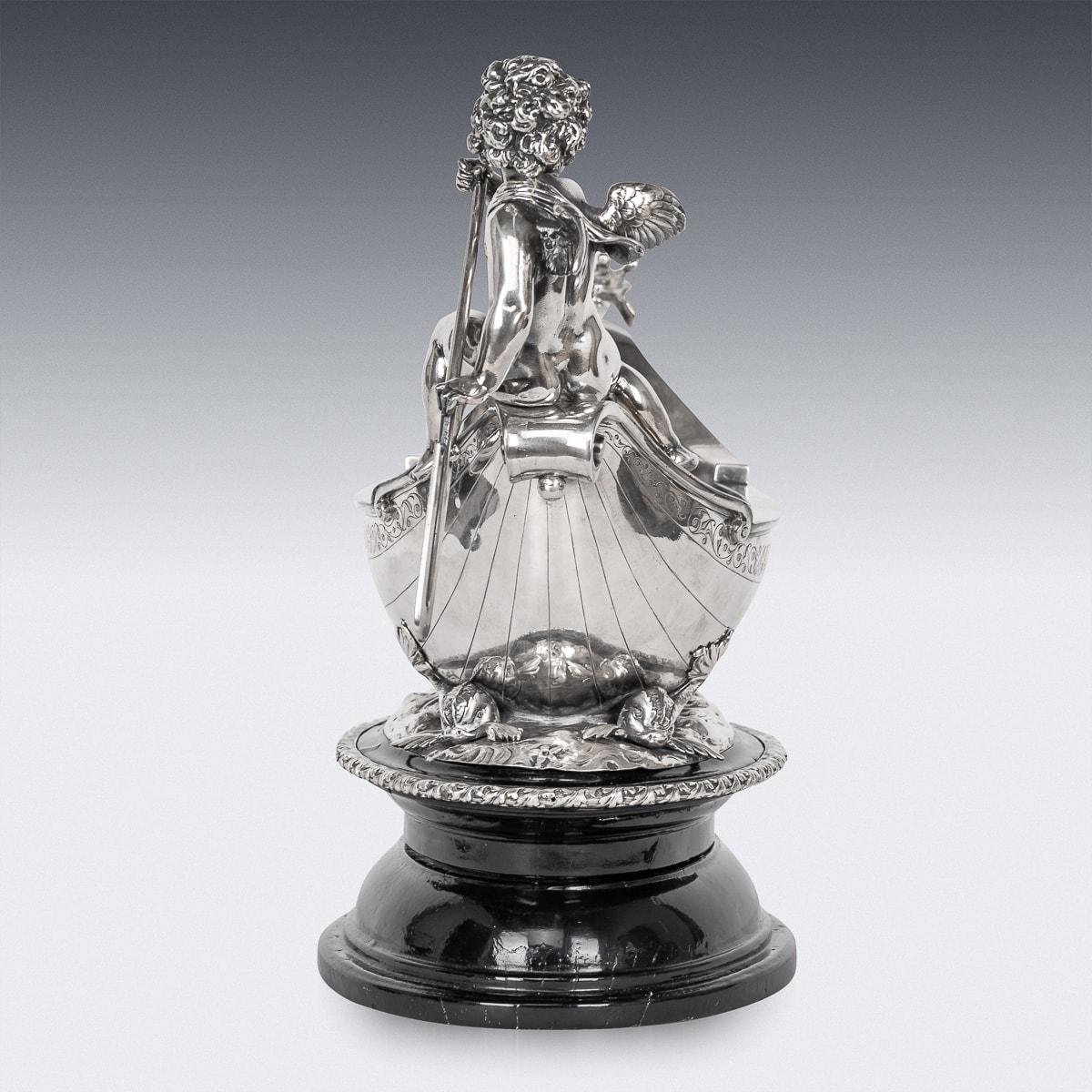 Antique early-20th Century Austrian exceptional solid silver centerpiece, crafted in the image of a majestic vessel, this remarkable piece features the regal visage of a beast adorning its prow, while a celestial cherub guides its course from the