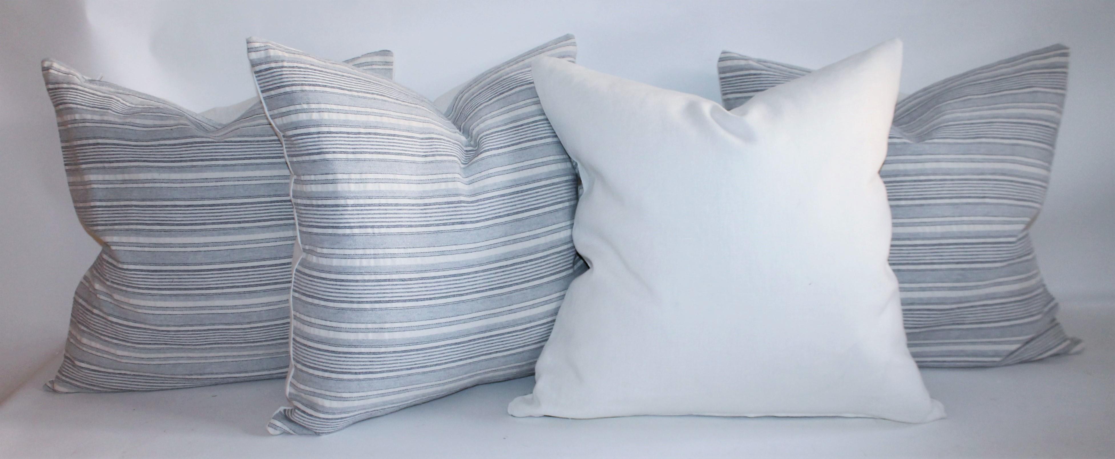 Vintage blue and white ticking pillows with white cotton linen backing. The inserts are down and feather fill. Selling the collection of four pillows.