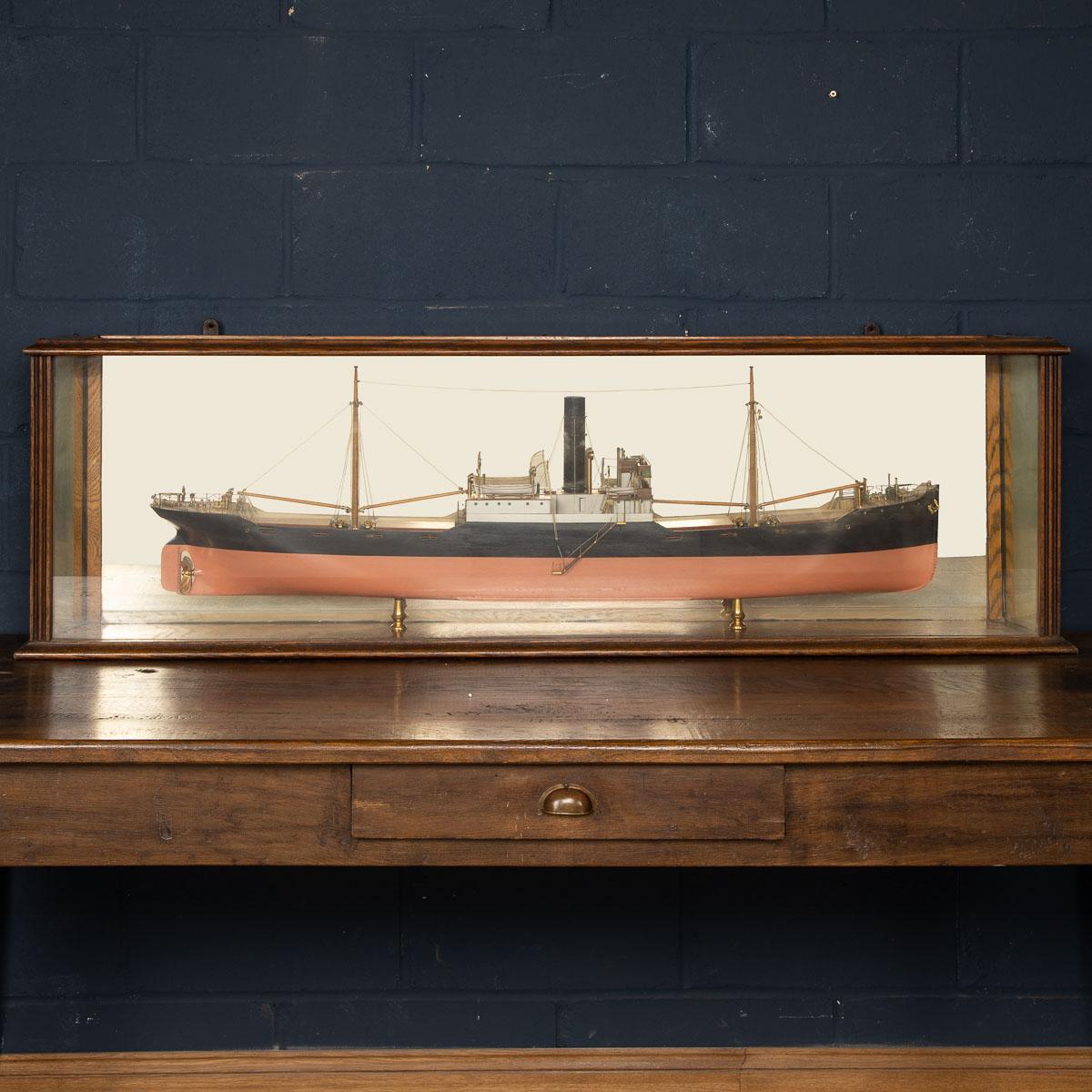 A stunning mid 20th century mirror backed boardroom half model of a steamer ship, the carved hull with bilge keel, lowered companionway and painted propeller with lined rudder, dark red painted deck with brown lined hatch covers and painted wood,