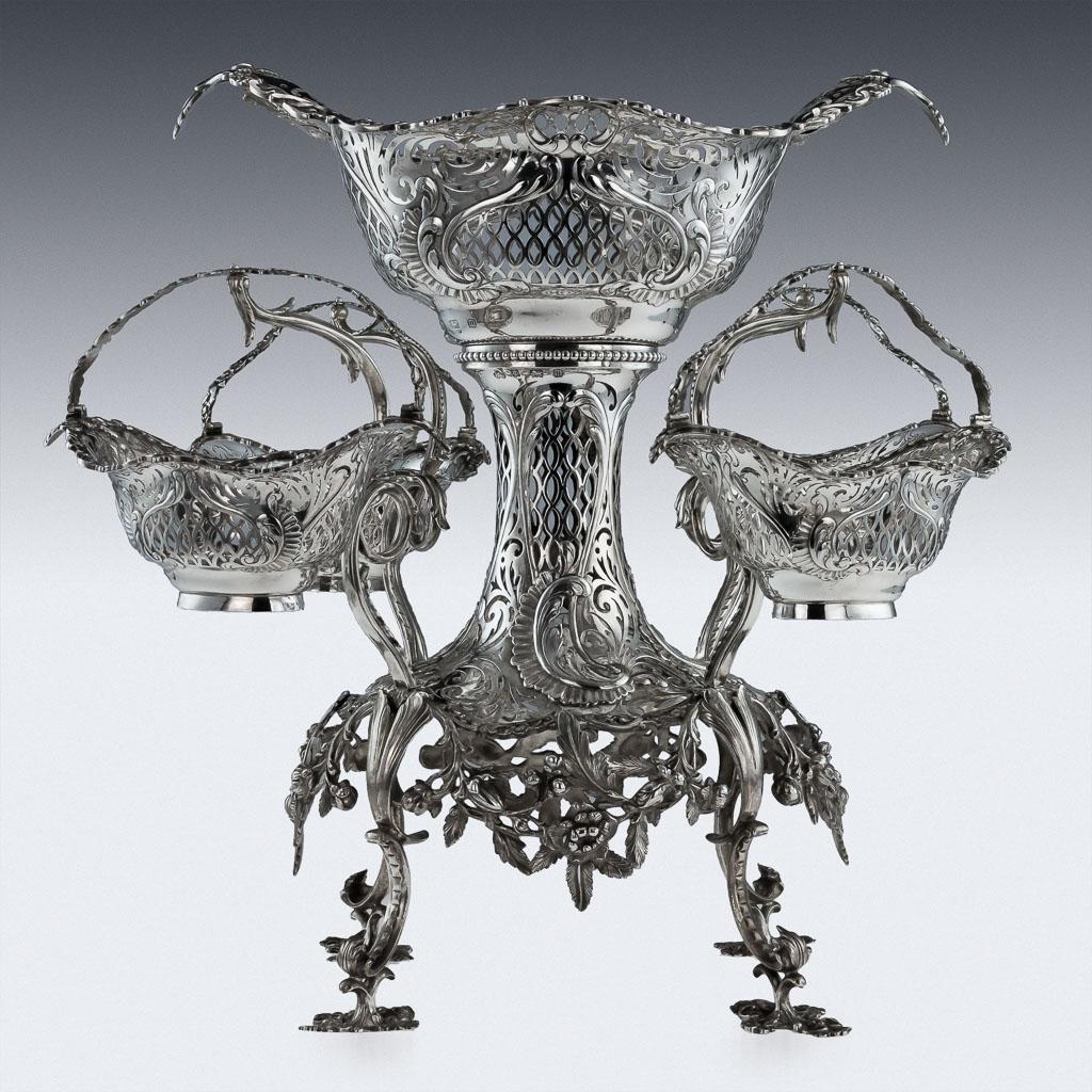 Antique 20th century Edwardian solid silver very large and impressive Epergne centerpiece, made in the Georgian style. This magnificent piece stands on four openwork scroll feet supporting a floral apron frame, the pierced body holding four scroll