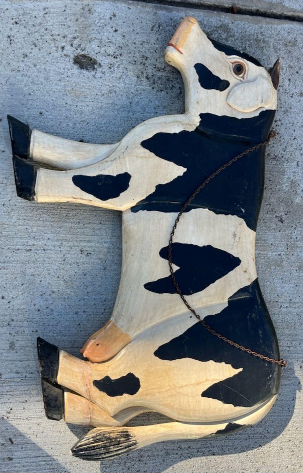 Early 20thc folky hand made cow trade sign.This full body cow hanging trade sign is double sided and has the original metal chain.The cow is hand carved & painted wood.
