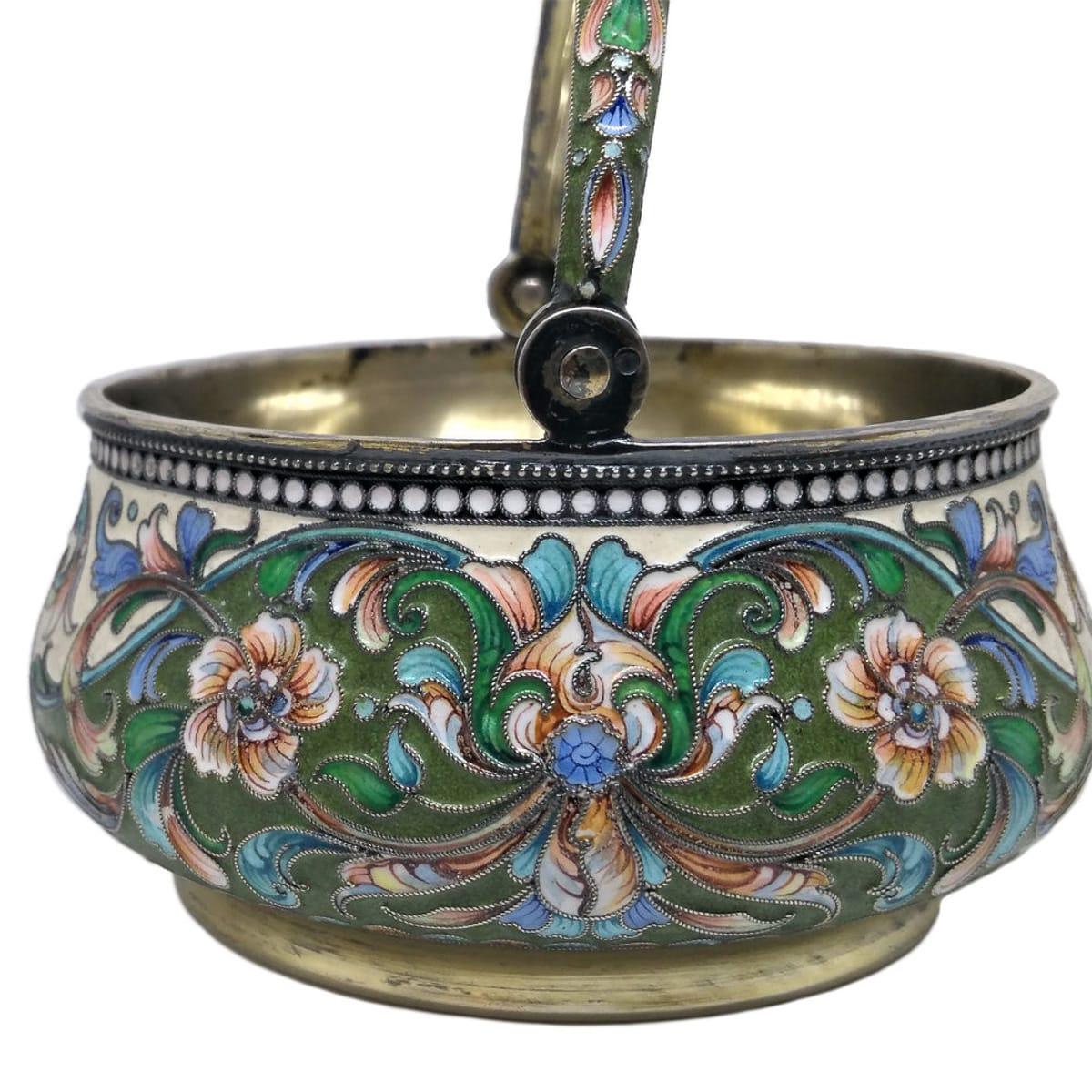 Antique early 20th century imperial Russian solid silver-gilt and cloisonné enamel sugar basket, of fine quality, richly gilt and beautifully enameled with multicolored stylized floral design on cream ground and applied with a swing handle.