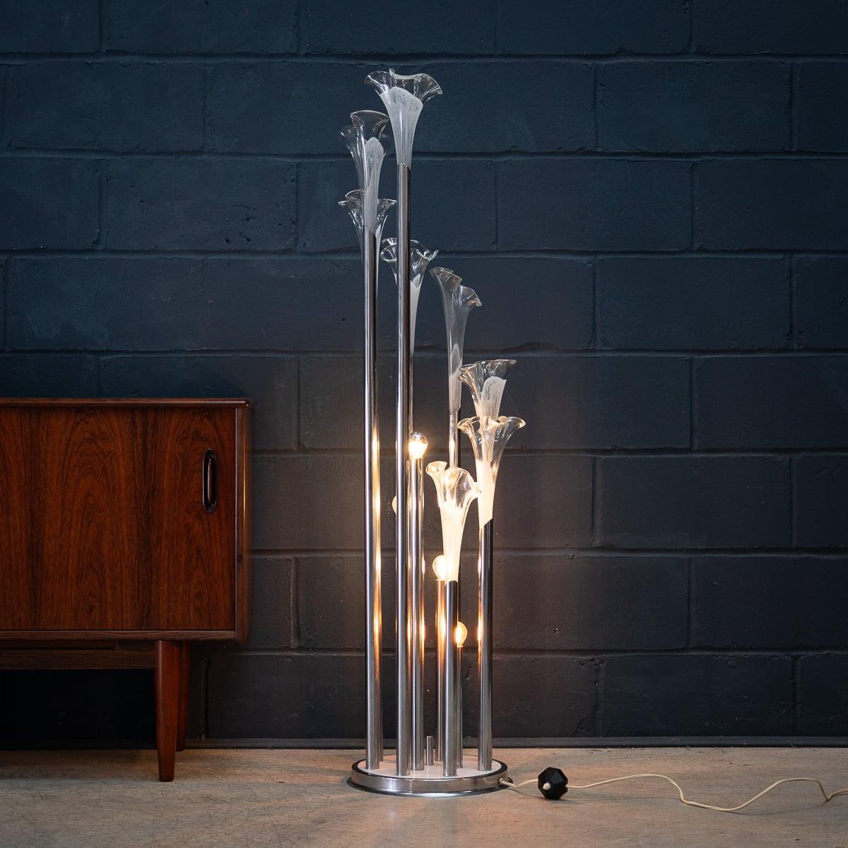 A rare and exquisite floor lamp, crafted in Italy in the 1970s. This lamp exemplifies refined Italian artistry with a strikingly modern twist. The lamp’s chrome structure elegantly supports eight tulip-like glass flutes, each hand-blown and