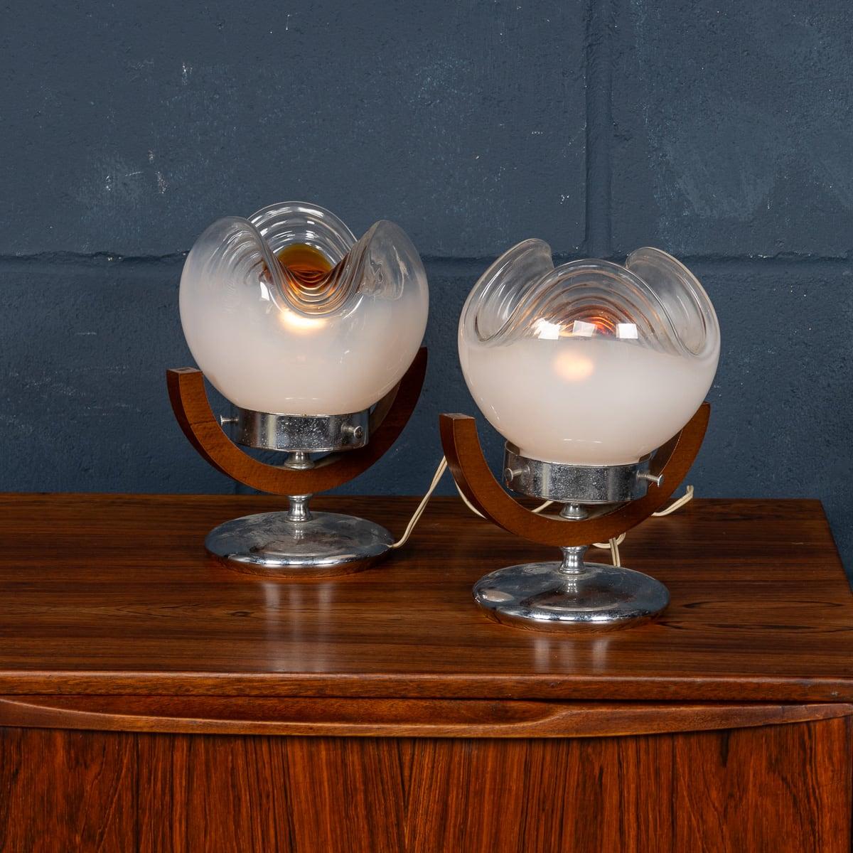 A delightful pair of side table lamps designed by Gaetano Sciolari for Mazzega, made in the famous island of Murano, Venice, in Italy around the 1970s. The chrome base supports an opalescent shade that becomes transparent and is then finished off