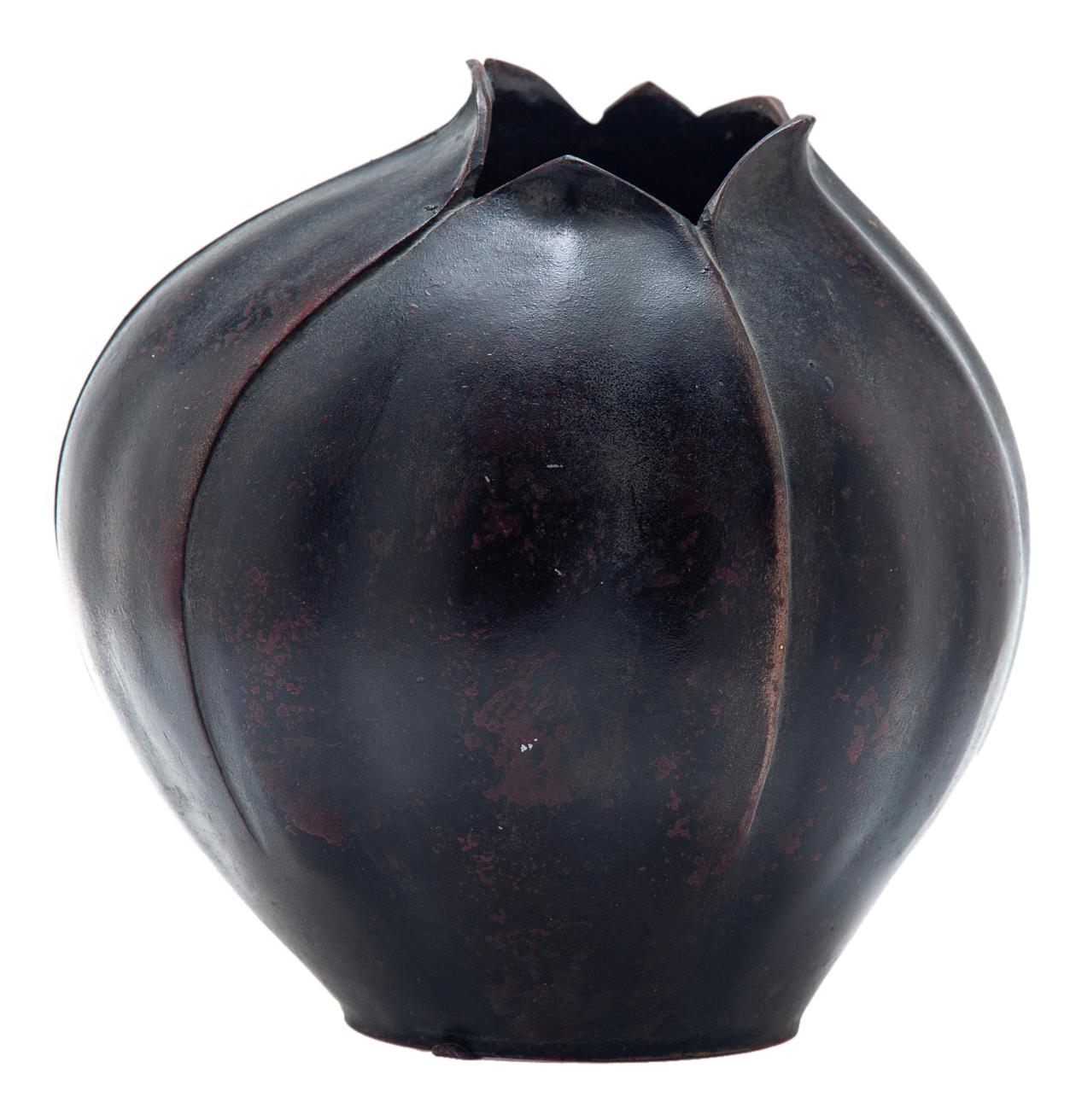 An elegant vase, organic impression of a lotus bud. The bronze reveals a deep earthy background with highlights on the leaf edges. The rubbed surface displays a reddish textured surface.
In Japanese culture, the lotus flower is revered for its
