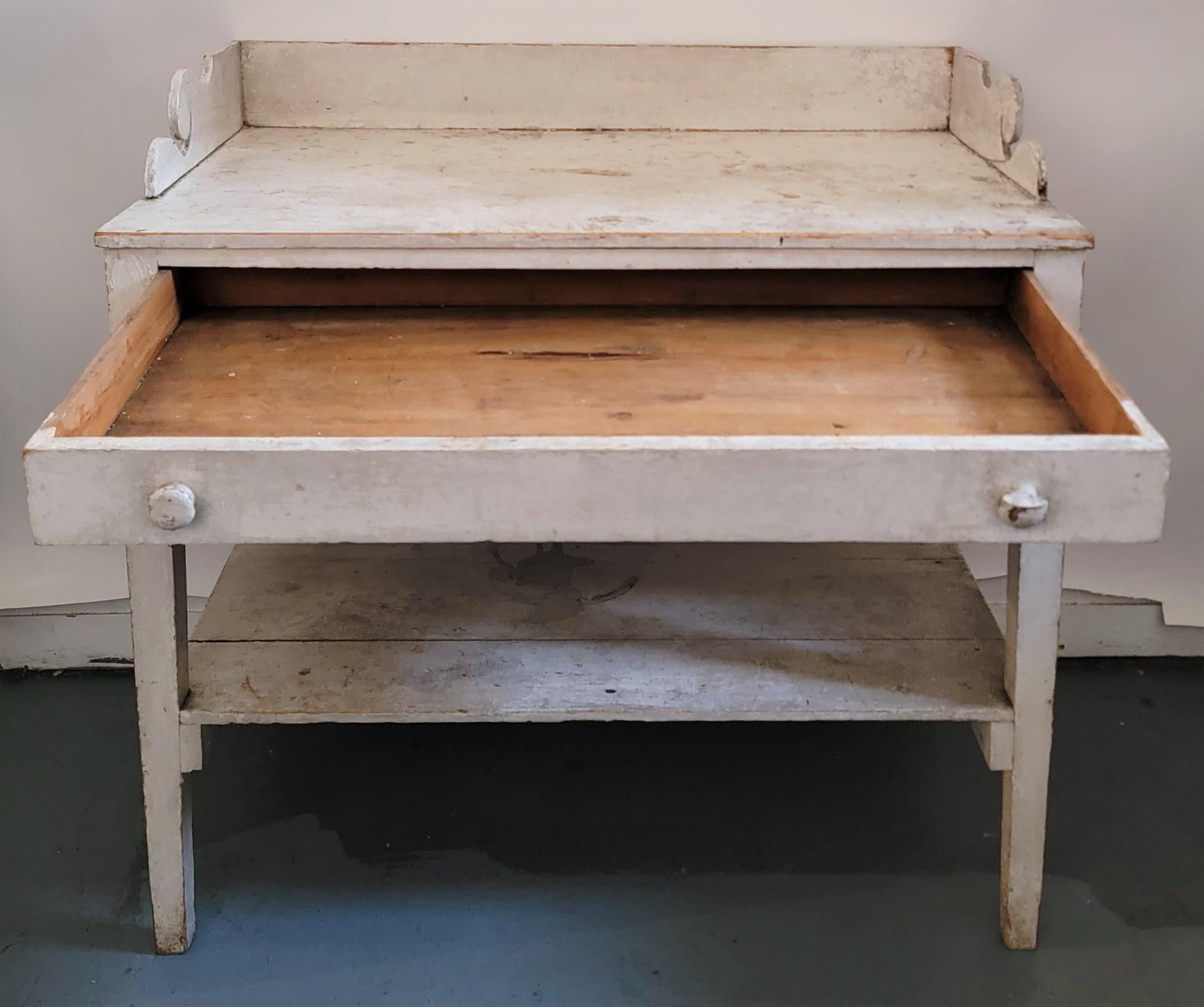 19th c Original white painted side table or server with one drawer. This finely made table has great details as a dovetail case and fantastic fine cut outs on the top case.The legs are taper and fine detailed.The condition is good and sturdy.