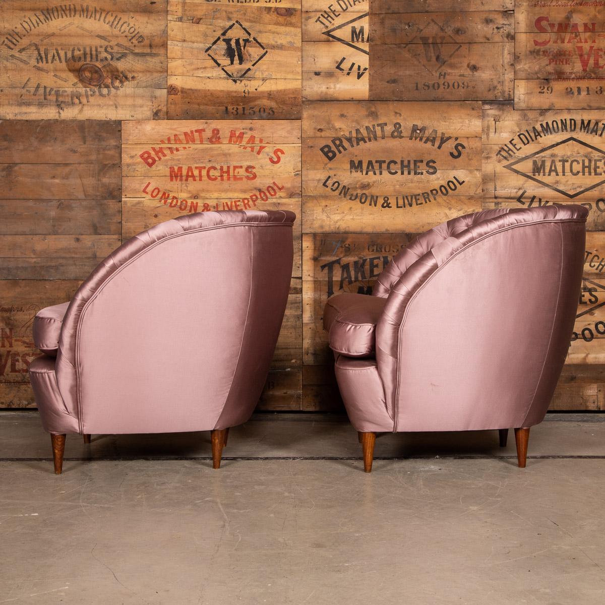 Elegant 20th century pair of boudoir tub chairs, recently reupholstered in a beautiful pink sateen fabric that shows the deep buttoning feature of these stunning chairs.