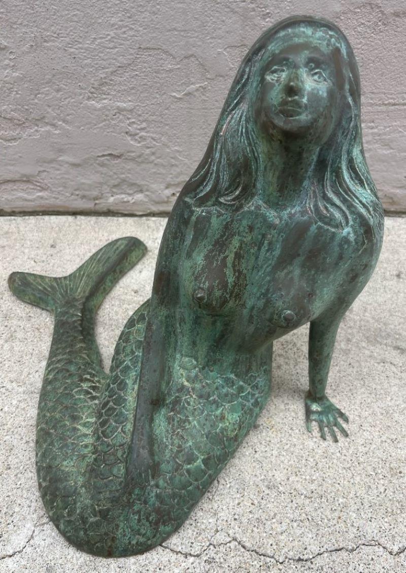 Statua di sirena in bronzo patinato del XX secolo. Condizioni incredibili con usura alla base.  La sirena a riposo ha un'incredibile patina verdognola che ha un'ottima età.
In ottimo stato.