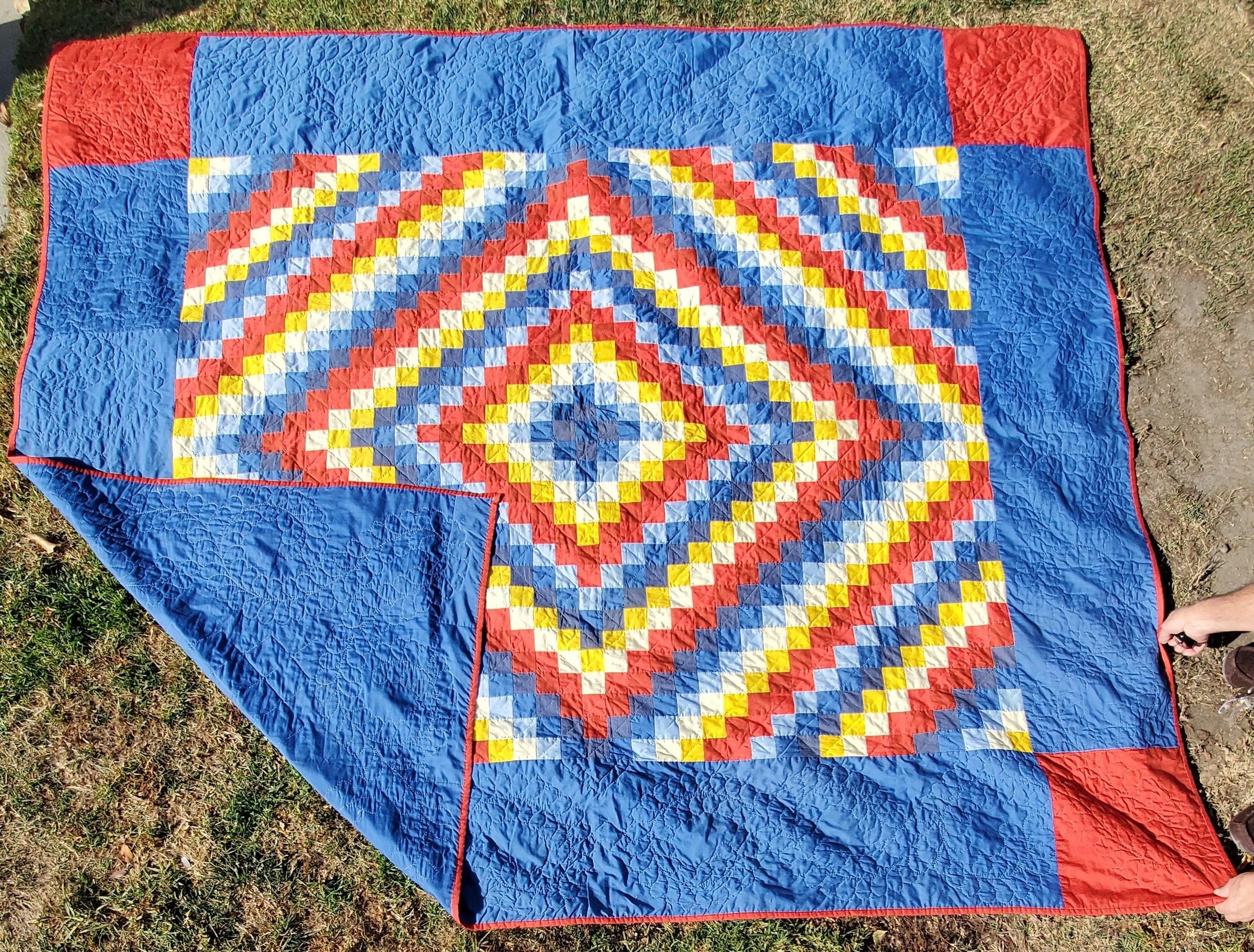 This finely quilted and pieced Philadelphia pavement quilt is in very good condition. The quilt is similar in pattern like a sunshine and shadow. The red corner blocks are a nice finishing touch. This quilt is all cotton and comes from Lancaster