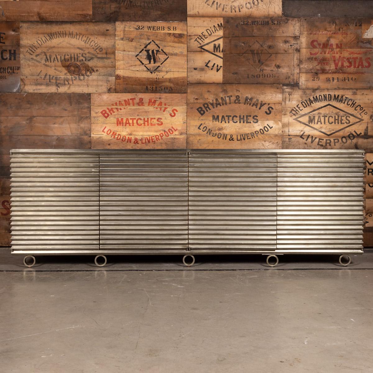 Stylish 20th century Portobello 4-door sideboard in variegated nickel with an aged mirror top standing on round nickel feet, lined inside with sycamore and 2 adjustable shelves, made by Julian Chichester.
 