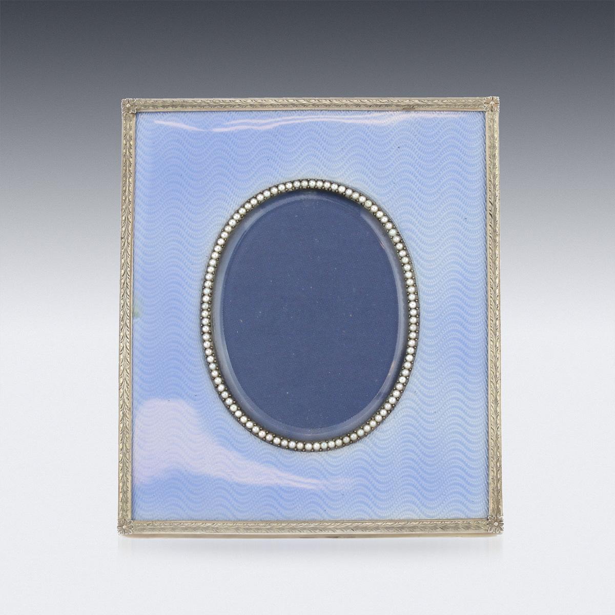 Antique early 20th century exceptional Russian Faberge silver gilt & guilloche enamel photograph frame, of rectangular shape, the sides applied with a leaf border set within translucent light blue-colored enamel over moiré engine-turning, beveled