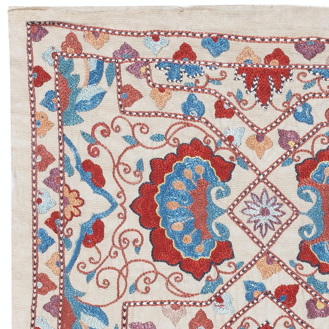 Zelebrieren Sie das reiche Erbe asiatischer Handwerkskunst mit diesem exquisiten Suzani-Textil aus 100 % Seide, das von erfahrenen Kunsthandwerkern sorgfältig von Hand bestickt wird. Dieses wahre Kunstwerk verkörpert eine jahrhundertealte Tradition
