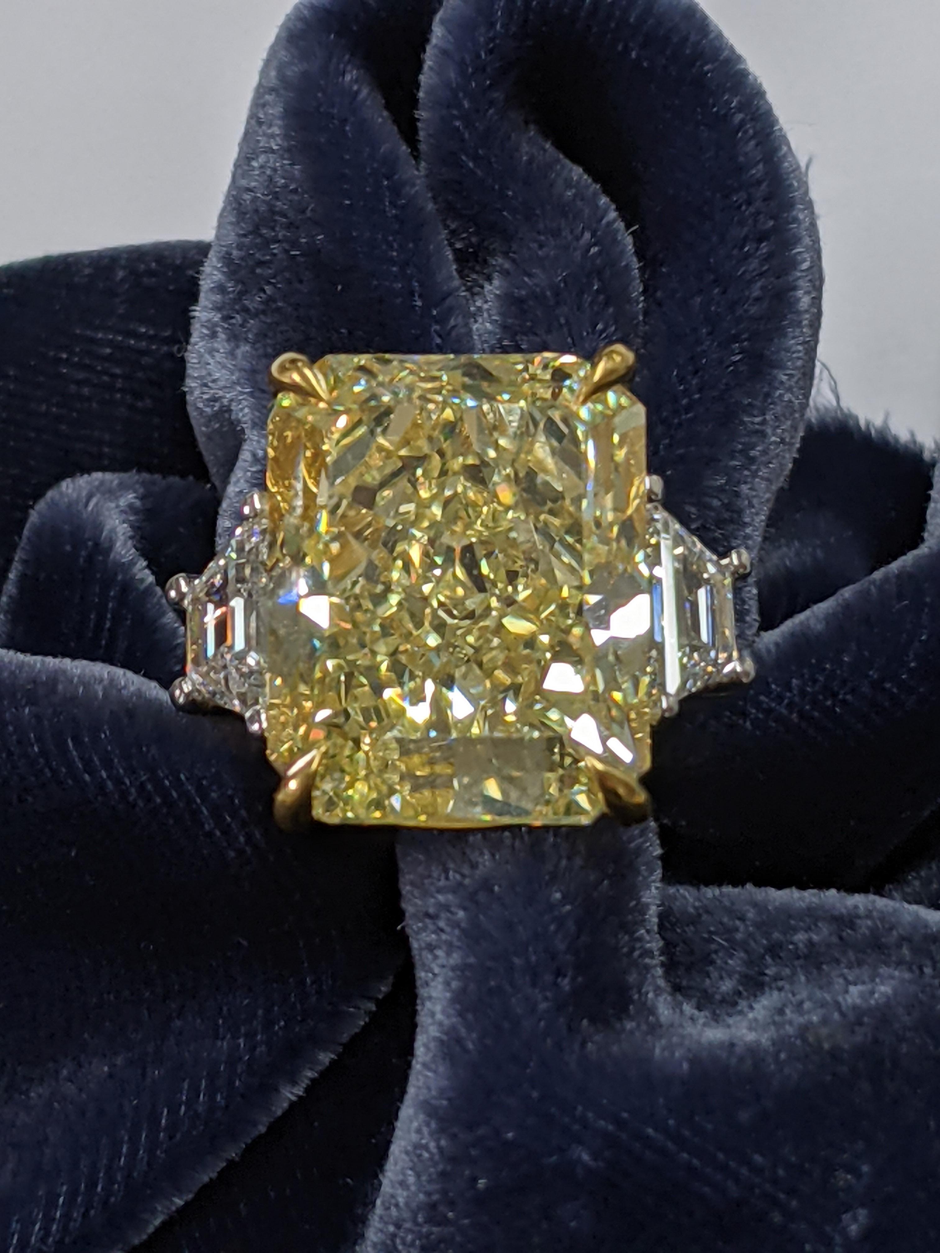 A statement diamond in a beautifully classic mounting this 21 carat Fancy Yellow Radiant Cut Diamond is GIA graded VS2 and set in the ultimate classic Park Avenue platinum styling by New York City's best diamond setters.  The side diamonds are white