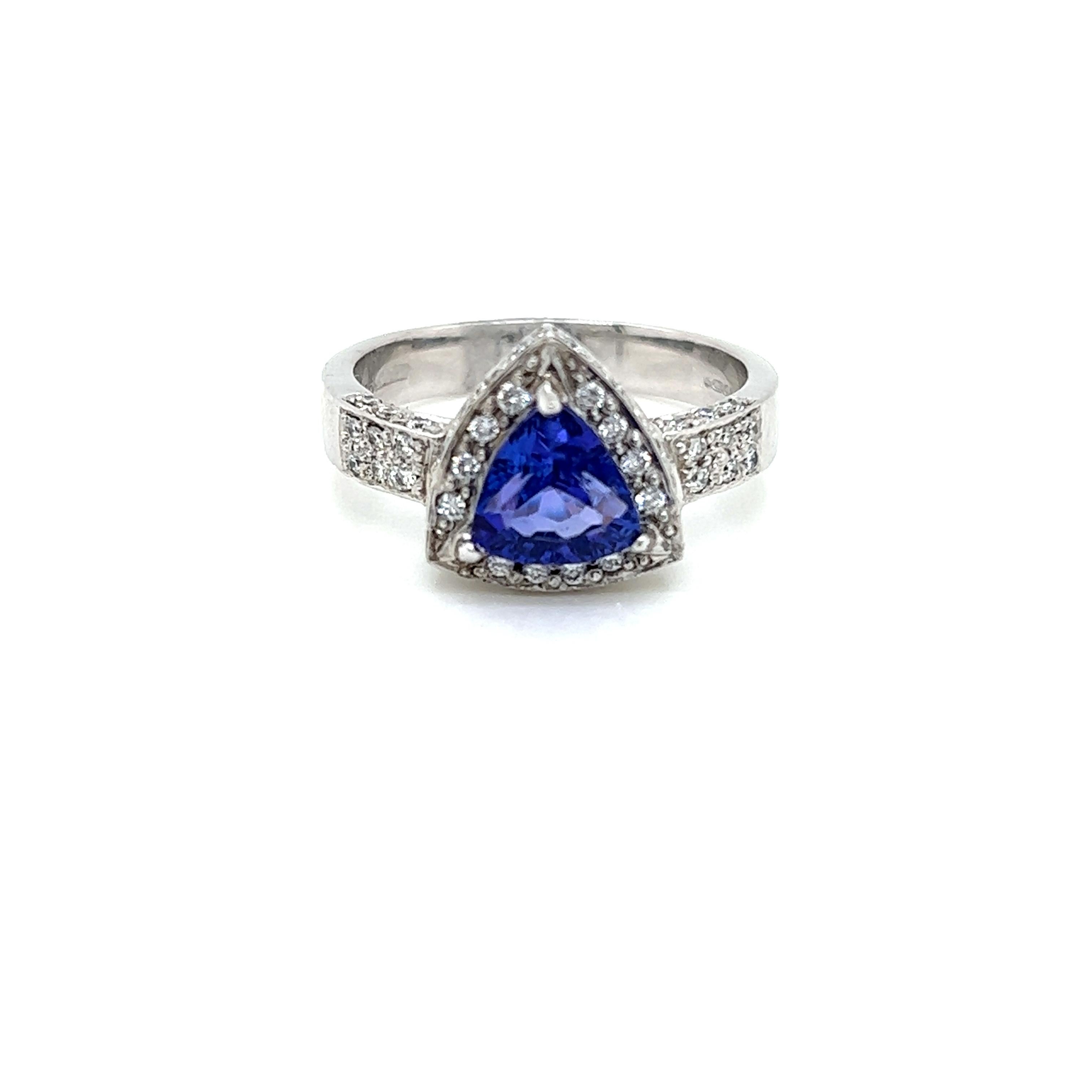 This striking ring features a stunning 2.1 carat Trillion cut Tanzanite at its centre. The lustrous, rich hues of this alluring stone are framed by glittering Diamonds and set on a diamond-encrusted Platinum band.  

The Diamonds on this ring weigh