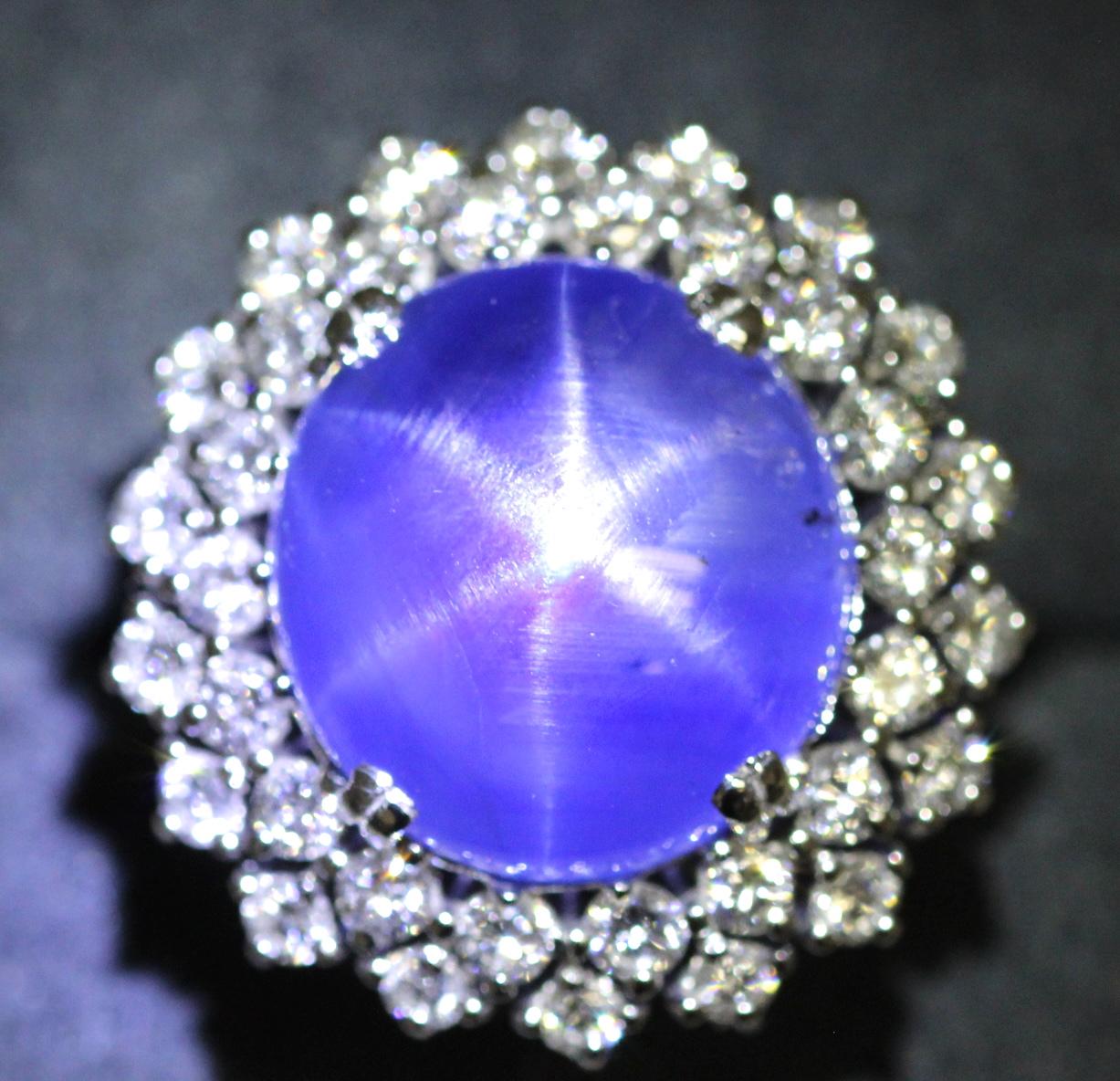A 1980's Vintage star sapphire and diamond ring. This cocktail ring features a natural, no treatment Ceylon star sapphire weighing approximately 21 carats. The Star sapphire is round domed cabochon shape with a rich cornflower blue appearance. We
