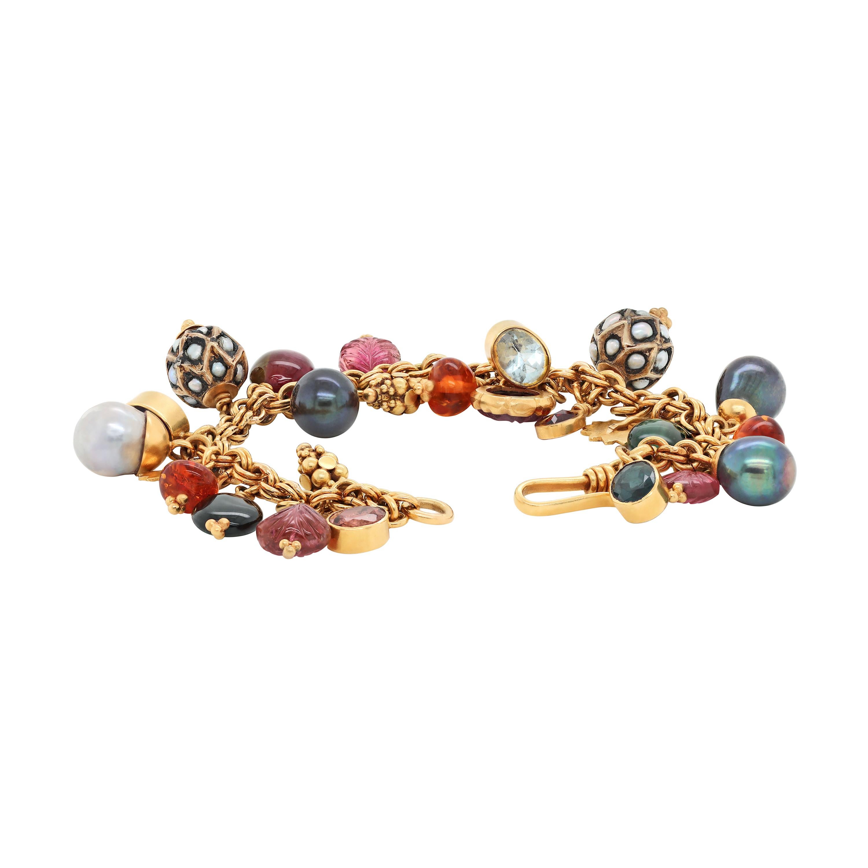 This unique charm bracelet features an assortment of beautiful semi-precious gemstones including pearls, tourmalines, citrines, aquamarines, sapphire, topaz and amethysts. All charms are attached to a double link cable chain, fitted with a secure