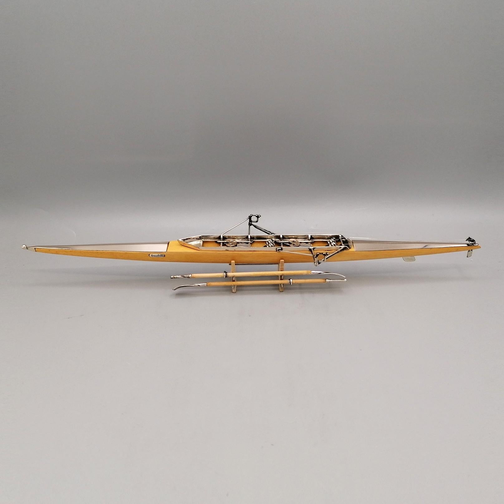 Sterling silver and wood racing canoe.
Miniature copy of rowing boat a coxless pair, abbreviated as a 2- and also known as a straight pair, is a racing shell used in the sport of competitive rowing. It is designed for two rowers, who propel the boat