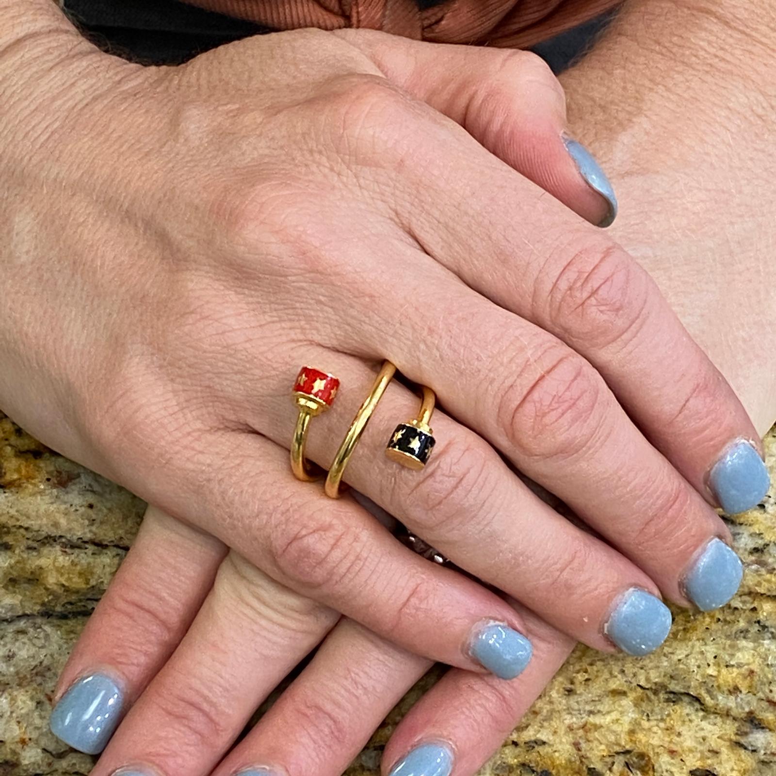 Black and red enamel coil ring fashioned in 21 karat yellow gold. The ring features black and red enamel star endcaps. The ring measures 1.0 inch in width and is size 6.5-7.0. 