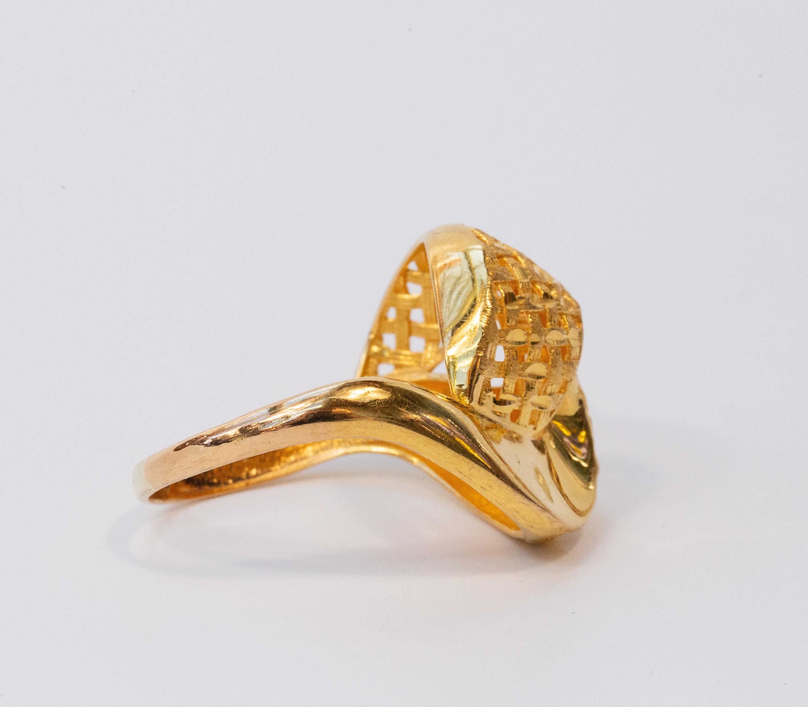 A vintage fashion ring with a curl, partly braided. The ring is made of 21 karat/875 yellow gold . The inner band of the ring is marked with 21K, in addition the ring tested as 21 karat gold. The gold color is bright and intense. The ring features a