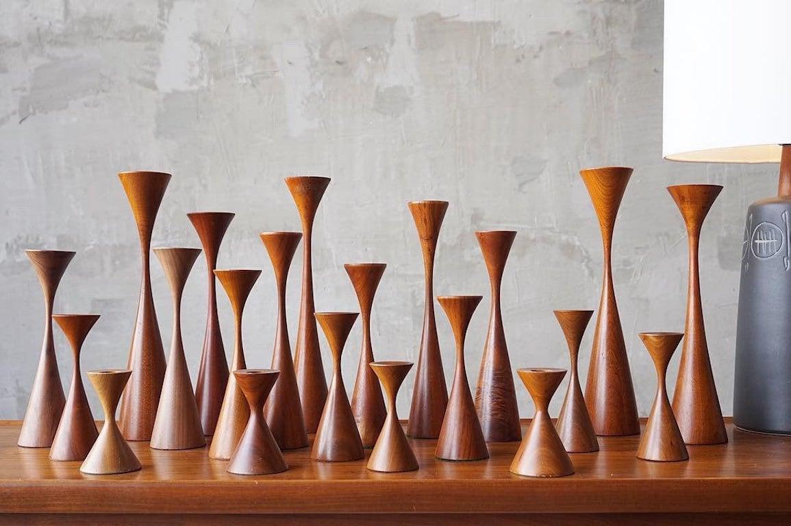 Beautifully crafted set of 21 studio made solid walnut candlestick holders by noted wood worker, Rude Olosnik. While each is attractive on its own, they are incredible as a large set. 

All retain original felt bottoms, some of which very faintly