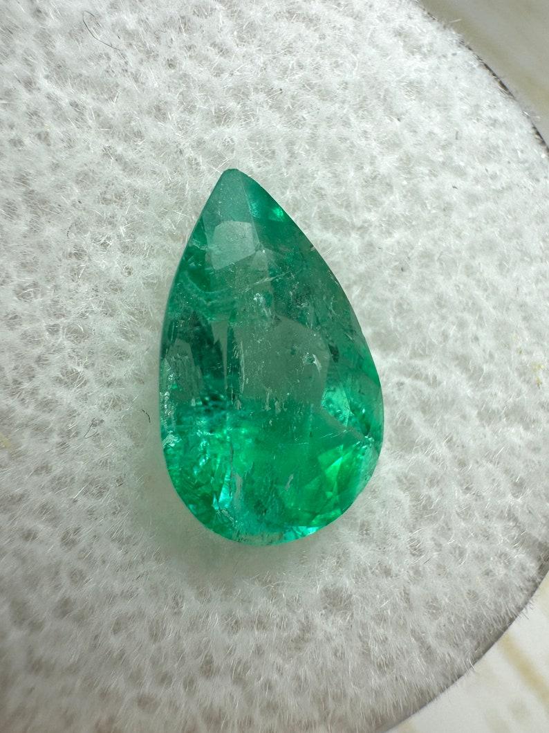 Stone: Emerald
Weight: 2.10-carats
Shape: Pear Cut
Clarity: Transparent
Luster: Very Good
Color: Bi-Color Green, Light green throughout the gem, and towards the bottom the gem showcases deep green color. Unique find!
Measurements: 11.30mm x 7.29mm x
