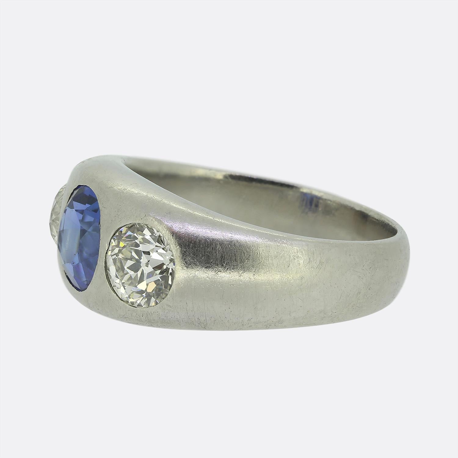 Nous avons ici une bague sensationnelle à trois pierres. Cette pièce en platine met en valeur un magnifique saphir rond à facettes d'origine birmane, d'un bleu puissant. Cette pierre principale attire l'attention au centre du visage, tandis qu'elle