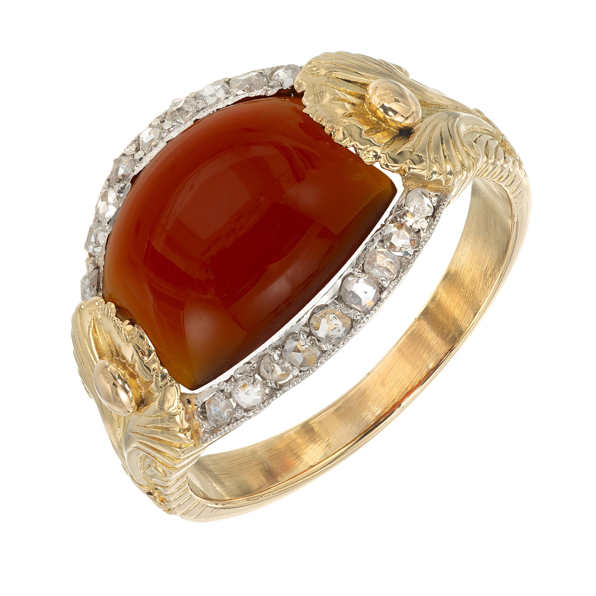 Anello antico del 1880 con corniola cabochon e diamanti in oro giallo 18 carati e platino. La corniola vibrante da 2,10 carati che ne costituisce il cuore è una gemma infuocata che cattura il calore di un sole al tramonto, splendidamente circondata