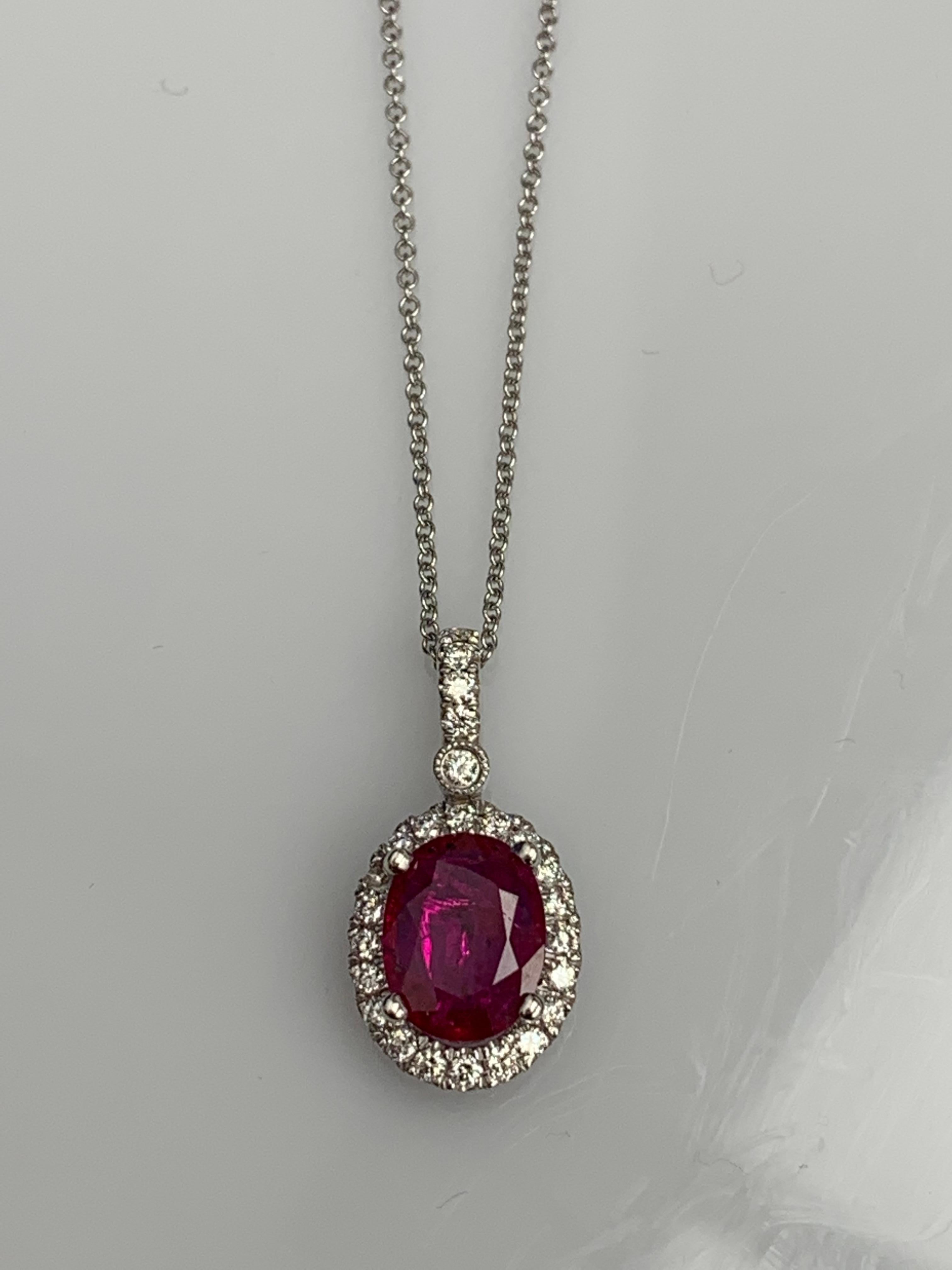 Un collier à pendentif simple mettant en valeur un rubis rouge ovale de 2,10 carats, entouré d'une pierre de taille. 
0,75 carats de 25 diamants ronds accentués. Fabriqué en or blanc 18 carats.

Le style est disponible dans différentes gammes de