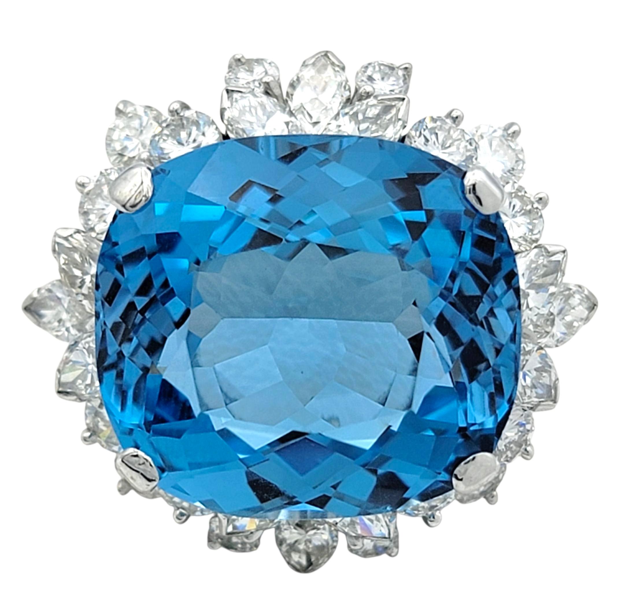 Questo ciondolo mozzafiato mette in mostra un vivido topazio blu svizzero con taglio a cuscino a scacchiera. La gemma irradia una brillante tonalità oceanica e le sue sfaccettature riflettono la luce con eccezionale scintillio e profondità. Intorno