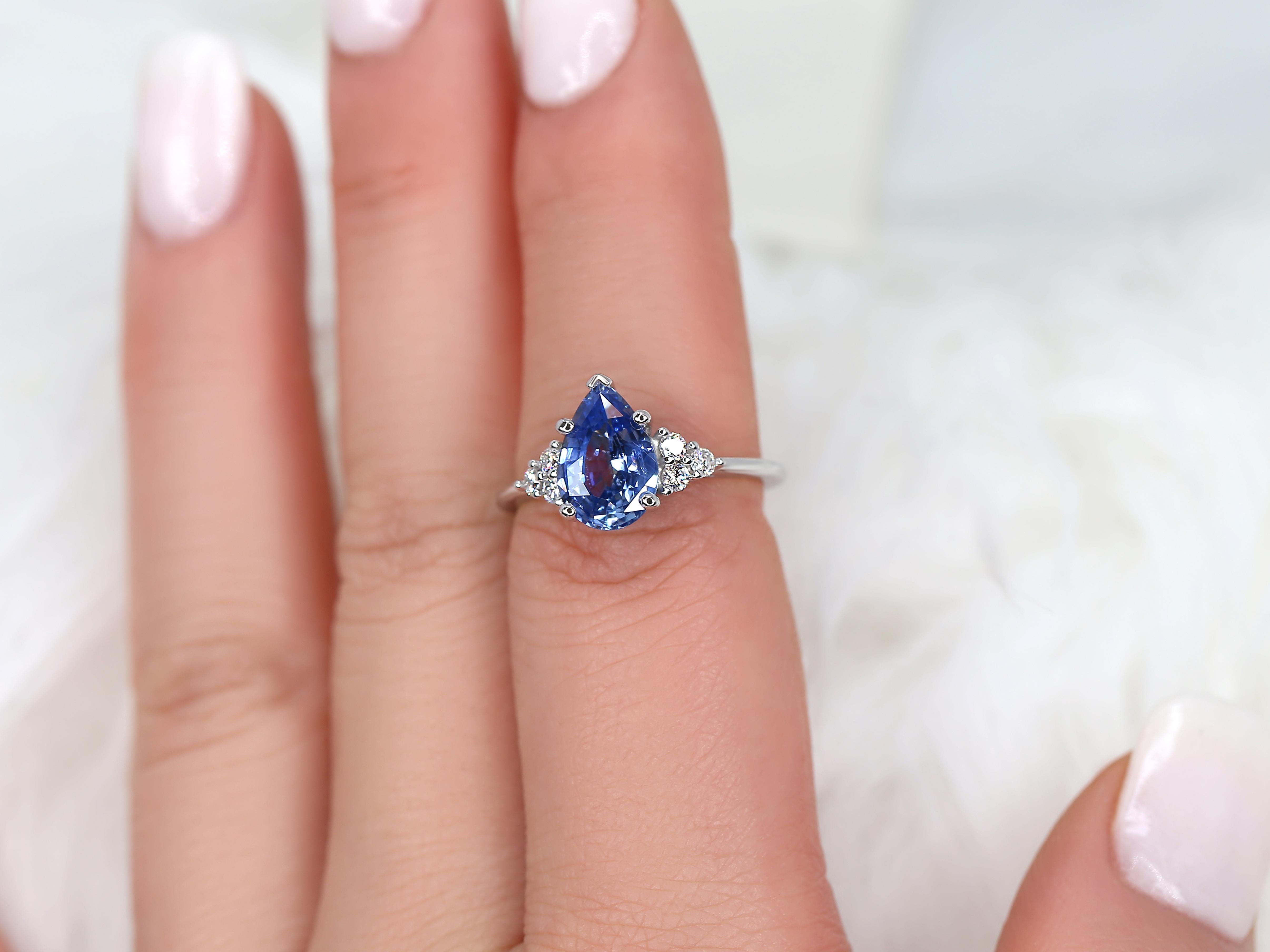 Enhance your look with our stunning Juliet pear-cut cornflower blue sapphire cluster ring, meticulously crafted in 14kt white gold. Featuring sparkling side stone diamonds, this elegant ring adds a touch of sophistication and allure to your
