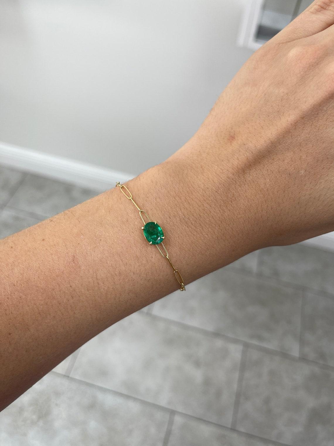 Voici un exquis bracelet trombone en émeraude qui respire l'élégance et le style. Au cœur du bracelet se trouve une magnifique émeraude ovale de 2,10 carats, d'un vert moyennement foncé, d'une clarté semi-transparente et d'un très bon lustre.