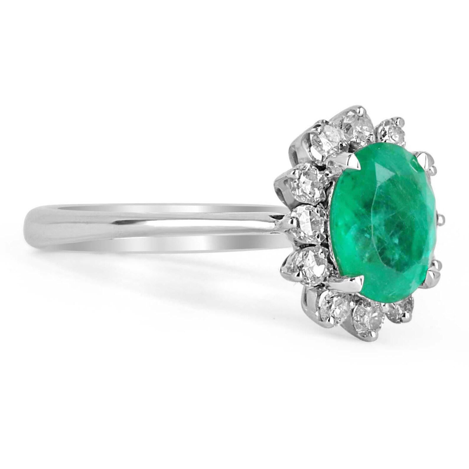 Featured is a vibrant Colombian emerald and diamond halo ring. The ring is made in solid 14k white gold. A beautiful oval emerald is the center of attention as it displays a soothing medium green color and excellent eye clarity. Diamonds halo around
