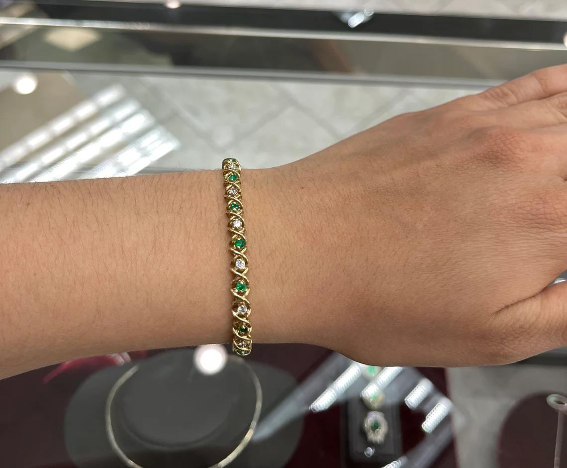 A remarkable emerald and diamond tennis bracelet. Fifteen stunning round cut-Colombian emeralds are seen throughout the entire piece, as well as fifteen glistering brilliant round cut diamonds follow along. Prong-set in a 14K yellow gold