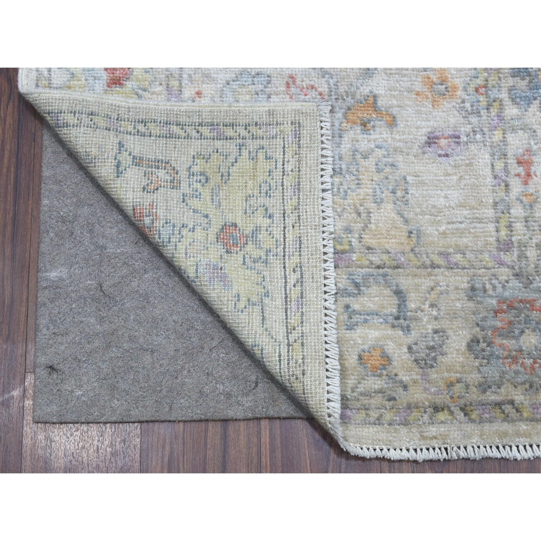 Il s'agit d'un véritable tapis noué à la main, doux, velouté et pelucheux, en Angora Oushak gris clair avec des motifs colorés, de type horizontal oriental XL. Il a été noué pendant des mois et des mois selon des techniques de tissage séculaires par
