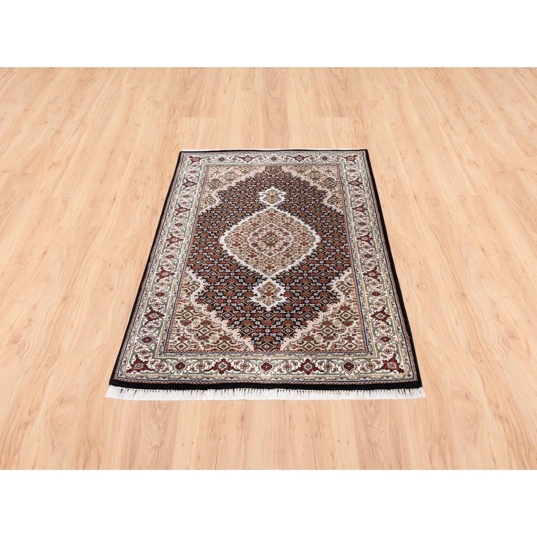 Il s'agit d'un véritable tapis d'Orient Tabriz Mahi en laine nouée à la main, de couleur noire, avec un motif de médaillon en forme de poisson, unique en son genre. Il a été noué pendant des mois et des mois selon les techniques séculaires du