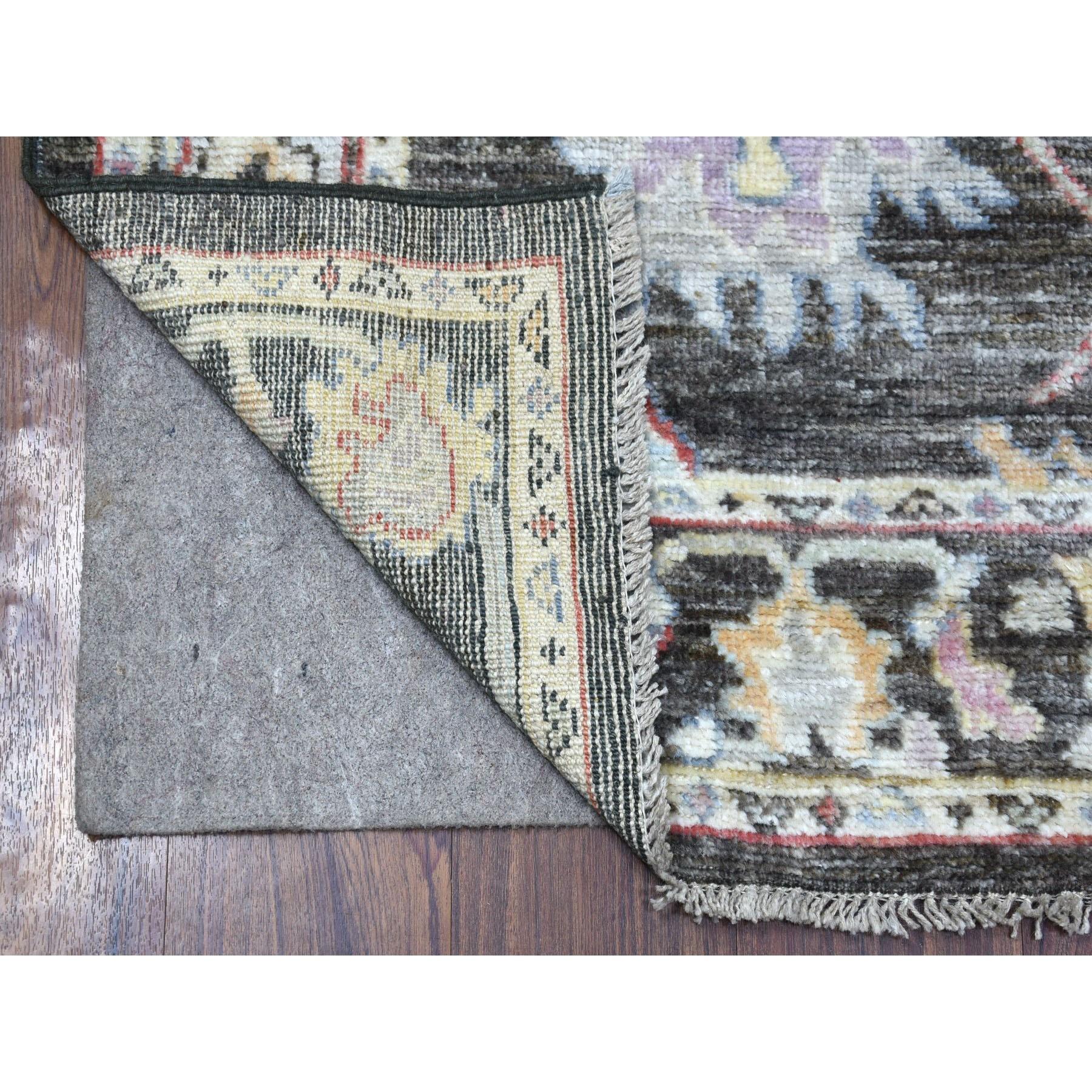 Il s'agit d'un véritable tapis de course oriental noué à la main, unique en son genre, de couleur noir anthracite, en angora Oushak, avec de grands motifs, et dont les poils de laine sont doux au toucher. Il a été noué pendant des mois et des mois